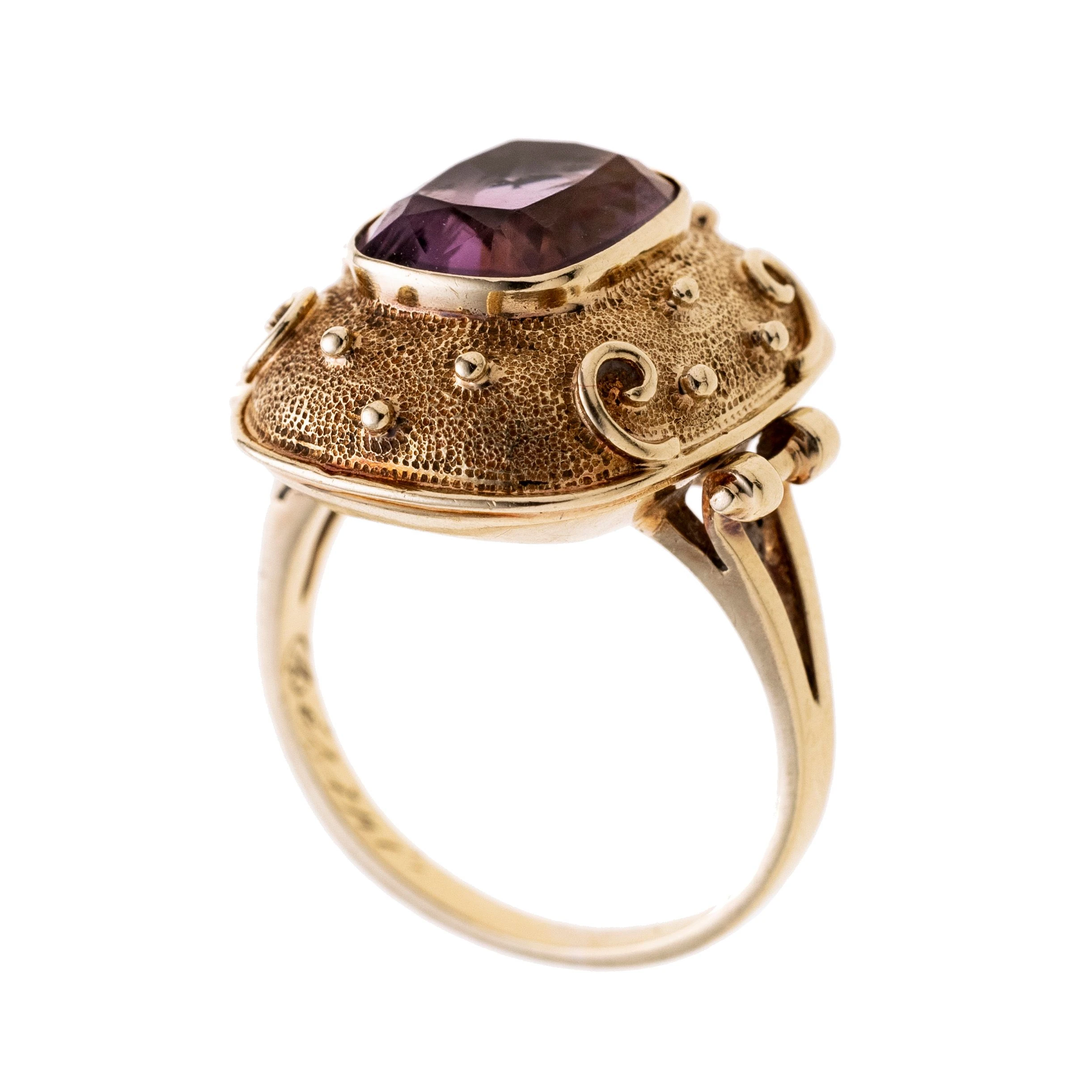 Ein Damenring gefertigt aus 585/- Gelbgold mit einem kissenförmigen, aufgewölbtem Ringkopf verziert mit Kügelchen und kleinen Schwüngen und einem mittig in einer Zargenfassung gefassten Amethyst von ca. 2,49 ct.
