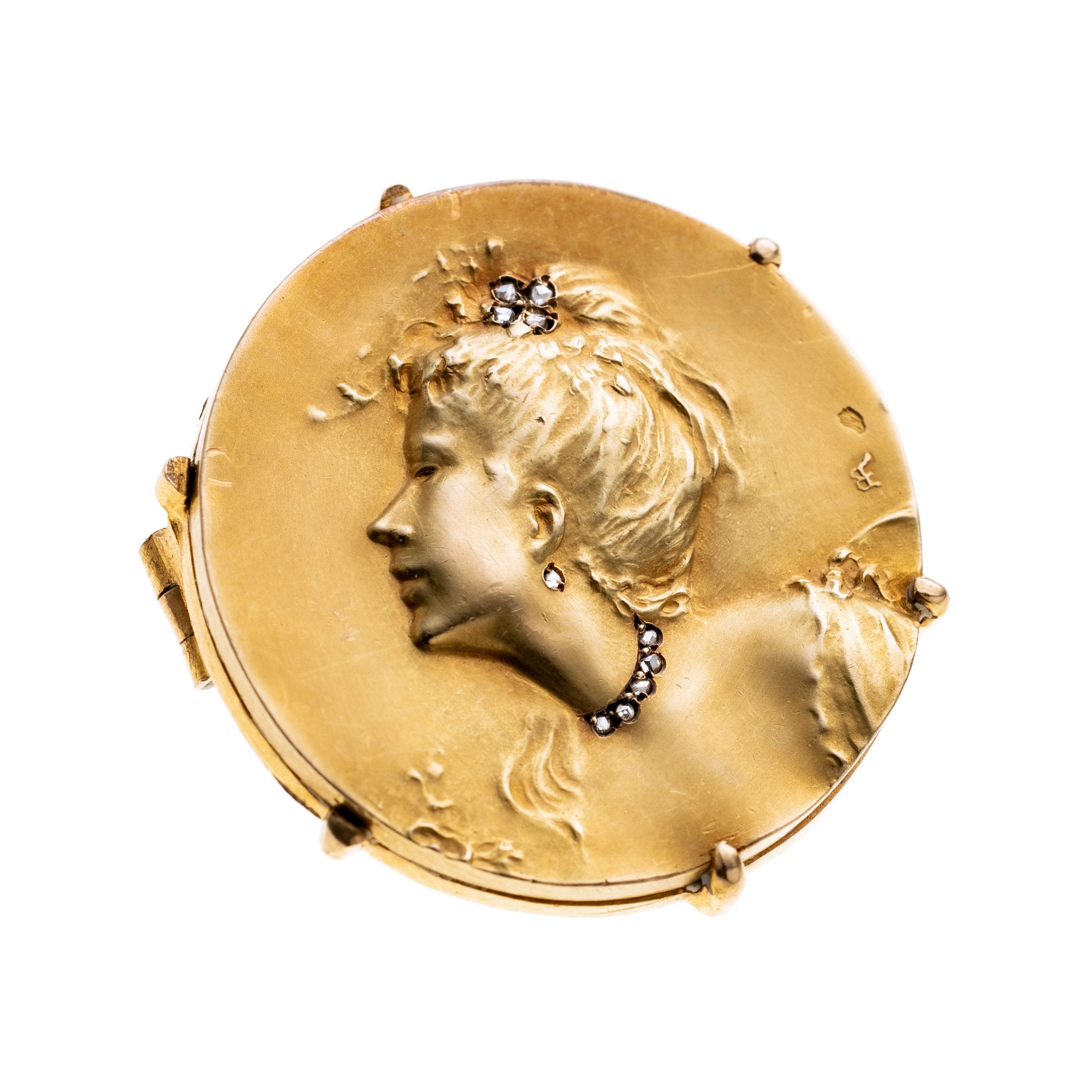 Eine Runde Anhängerbrosche um 1900 mit der Darstellung einer Frauenbüste mit hochgestecktem Haa, Ohringen, Halskete und Aigrette aus Diamantrosen (zusammen ca. 0.02 ct.) Entworfen von comte d'Epinay Briort (Medaillen-Juwel). zusatzlich signiert HM. Vgl. V. becker, Art Nouveau Jewelry, Abb. 145.