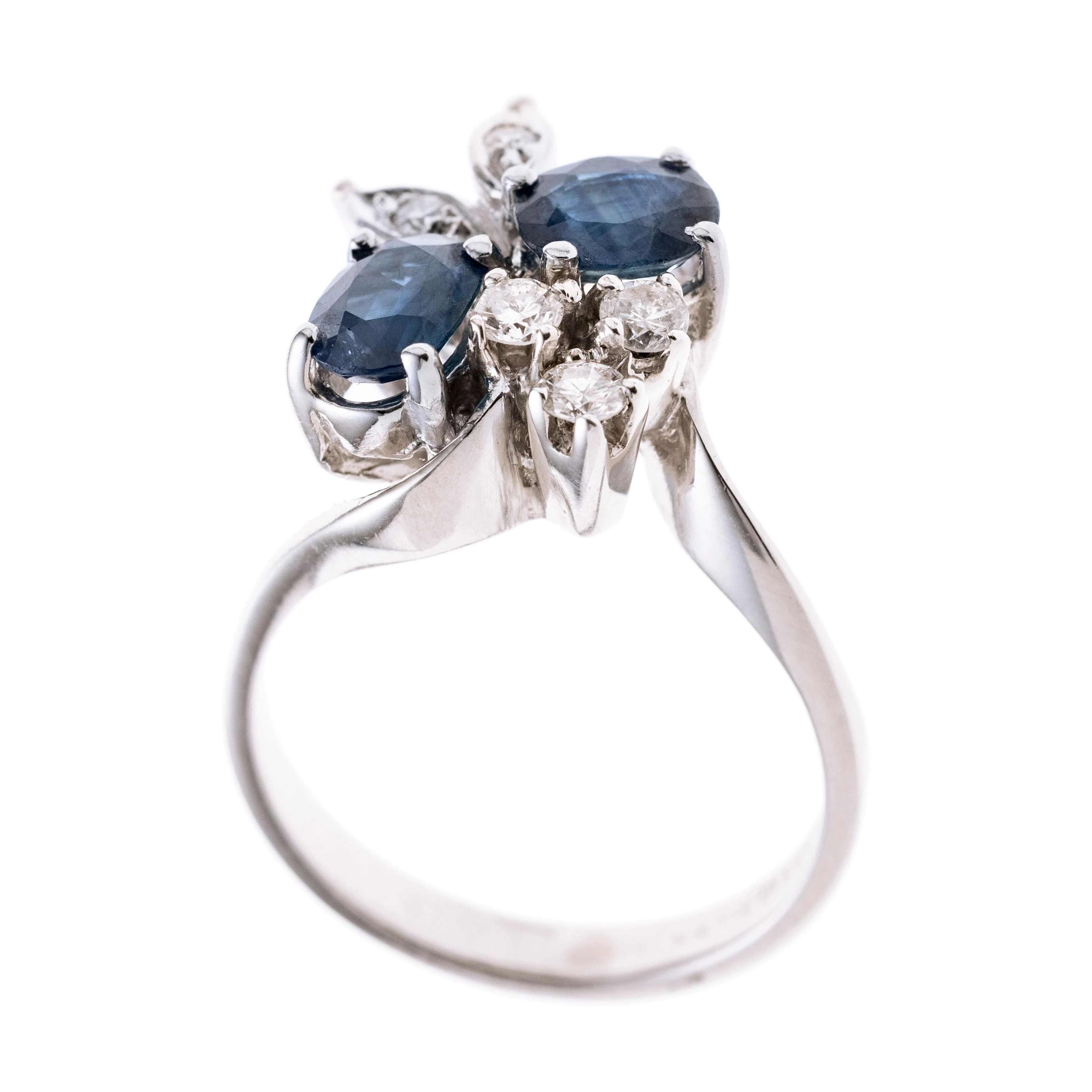 Ein floral anmutender Ringkopf besetzt mit zwei Saphiren und fünf Diamanten. Signiert.