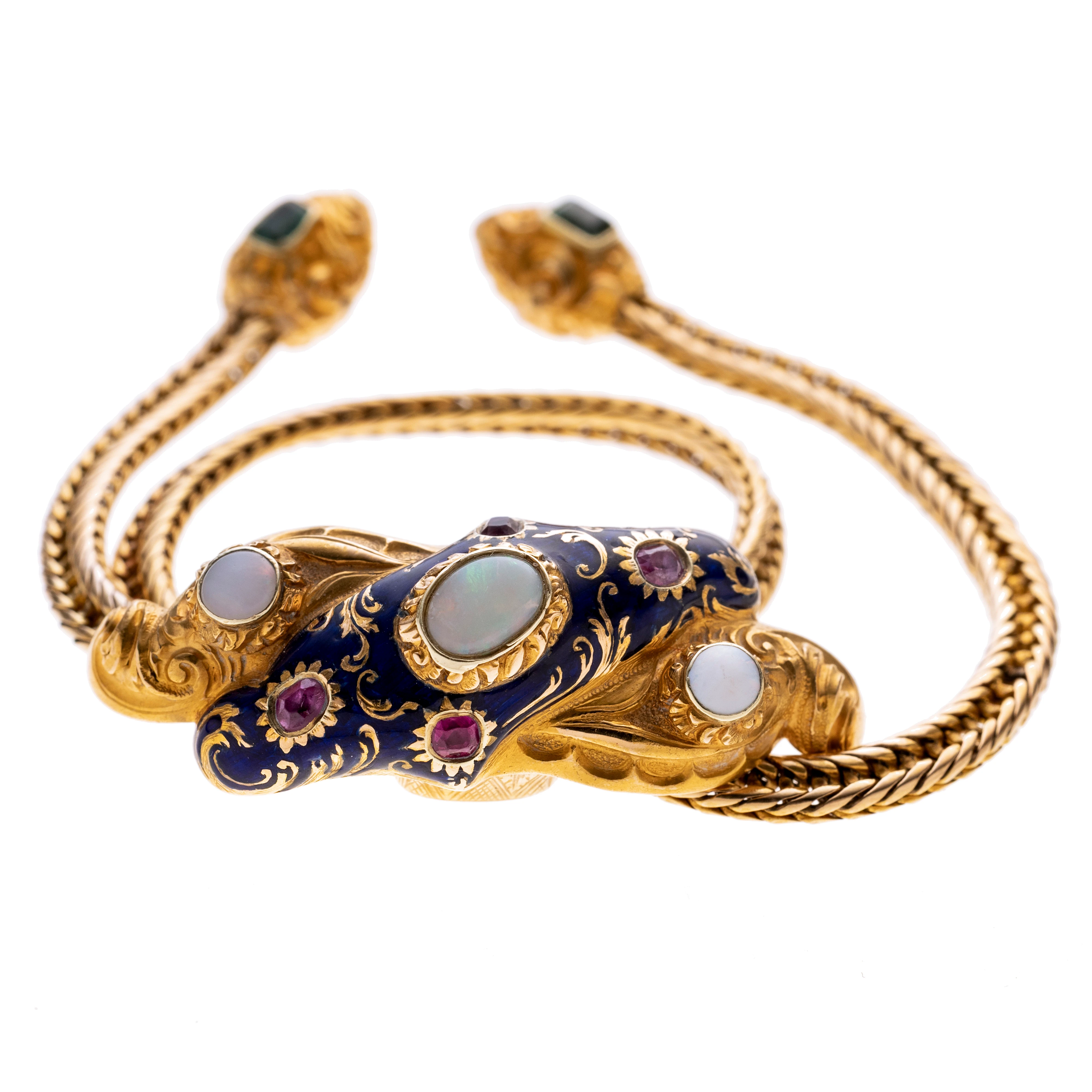 Ein Armband aus einer Kette mit zwei trofenförmigen Enden, die jeweils mit Rankenwerk verziert sind und einem Smaragd. Gehalten wird die Kette von einem Schleifenknoten ähnlichen Schieber der mit marineblauem Email verziert ist. Zudem fasst er drei Opale und vier Rubine. Die Rückseite des Schieber ist floral graviert. Der Umfang des Armbandes lässt sich flexibel verstellen.