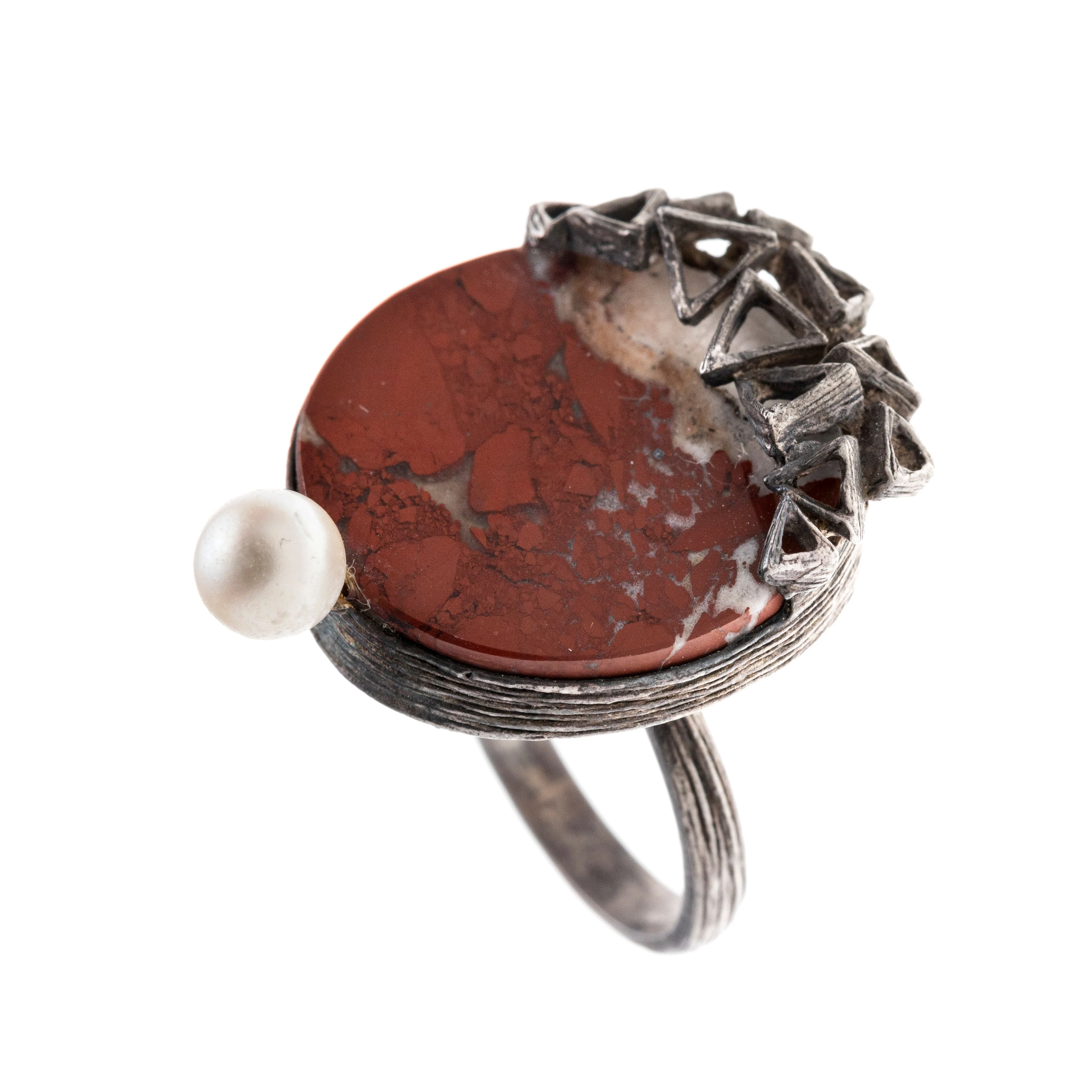 Ein Ring mit einer runden Achatscheibe, einer zierenden Perle und Dreieckornamentik als Ringkopf. Autorenschmuck.