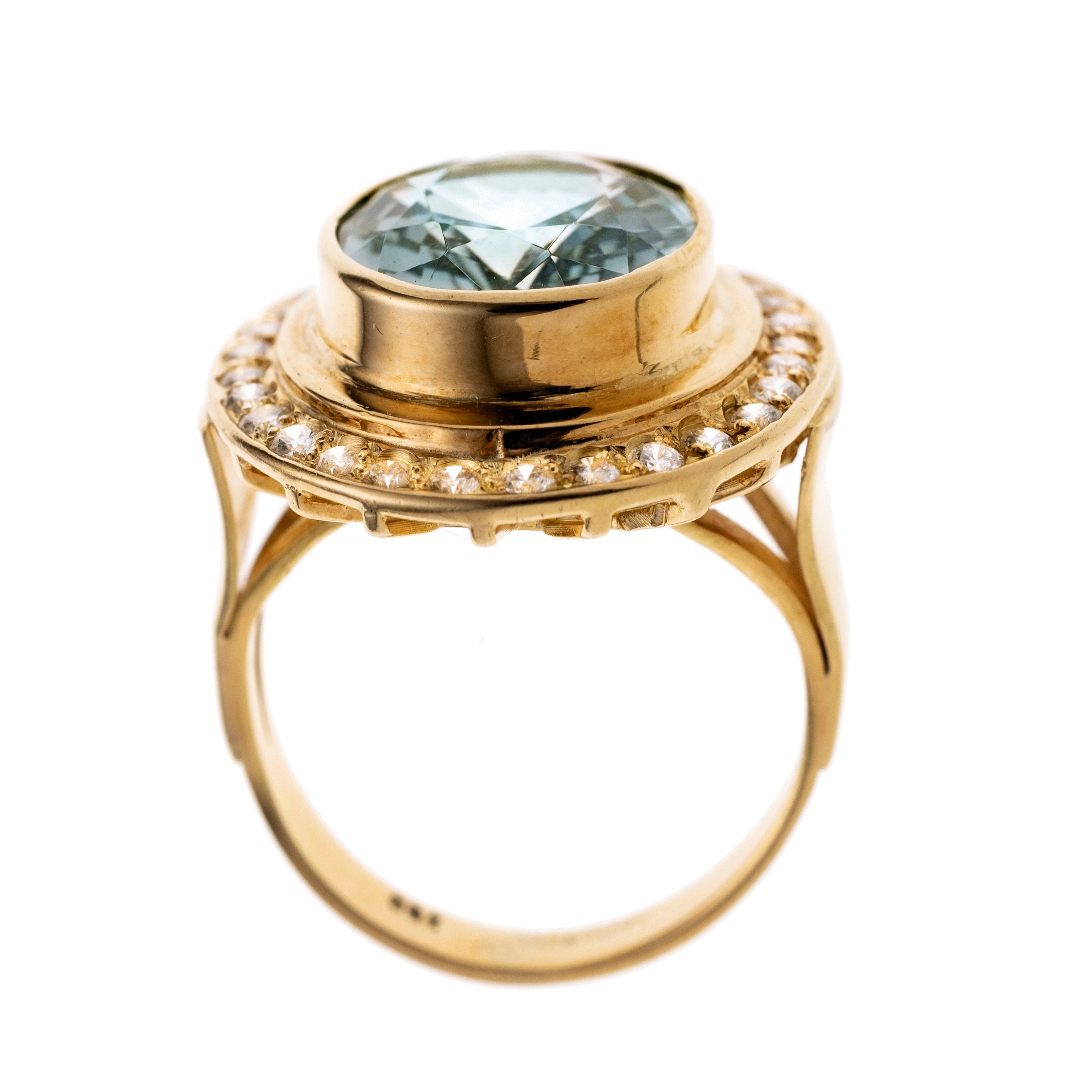 Ein ovaler Aquamarin in leicht erhöhter Zargenfassung der von 30 Brillanten je ca. 0.02 ct gerahmt wird.