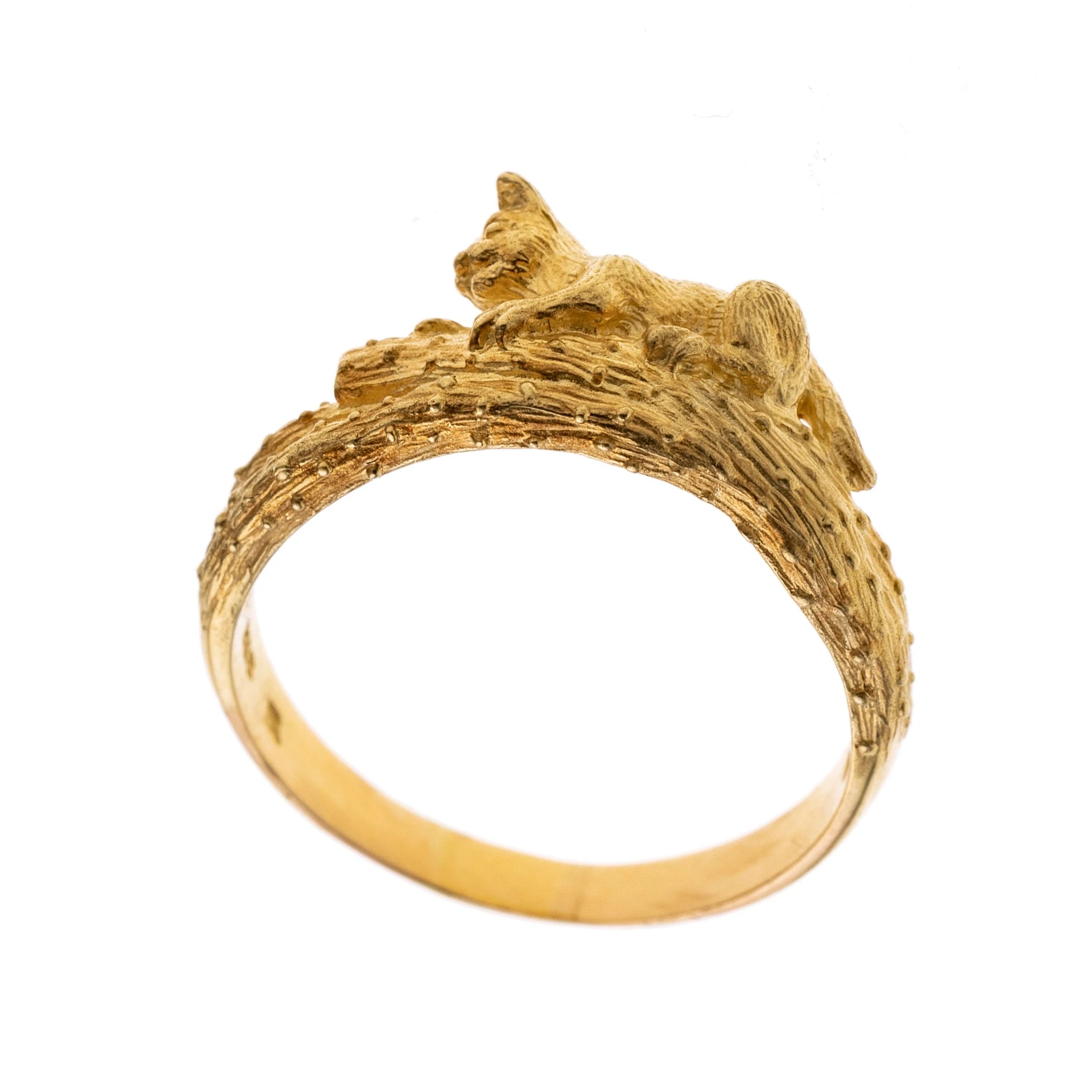 Weißgoldene Ringschiene gestaltet wie ein Ast, daran beweglich hängend befindet sich eine Katze mit einem Diamanten in der Hand.