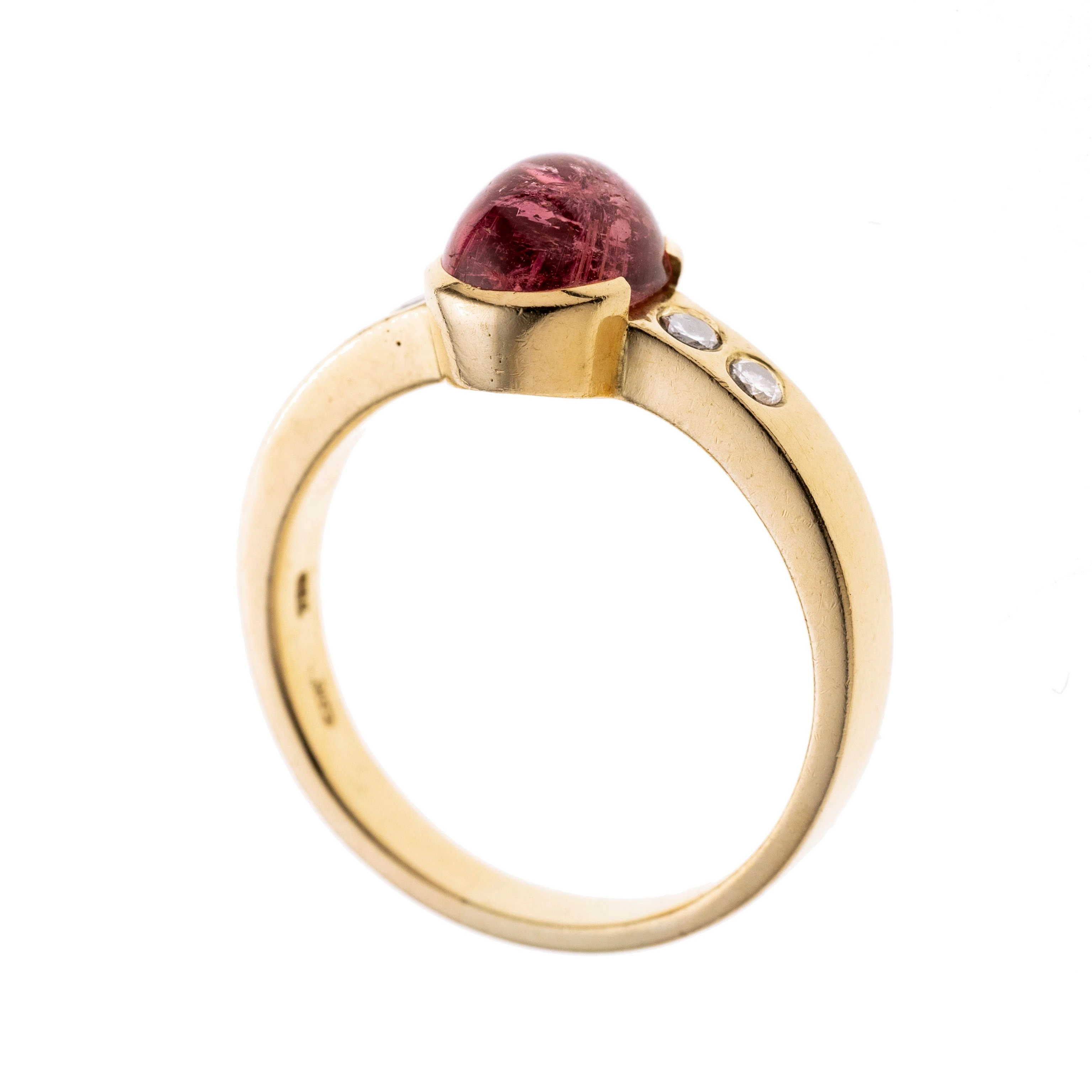 Ein Damenring gefertigt aus 750/- Gelbgold, mittig in einer Zargenfassung ein Turmalin-Cabochon, flankiert von je 2 Brillanten von total ca. 0,14 ct H/ vs1-si1
