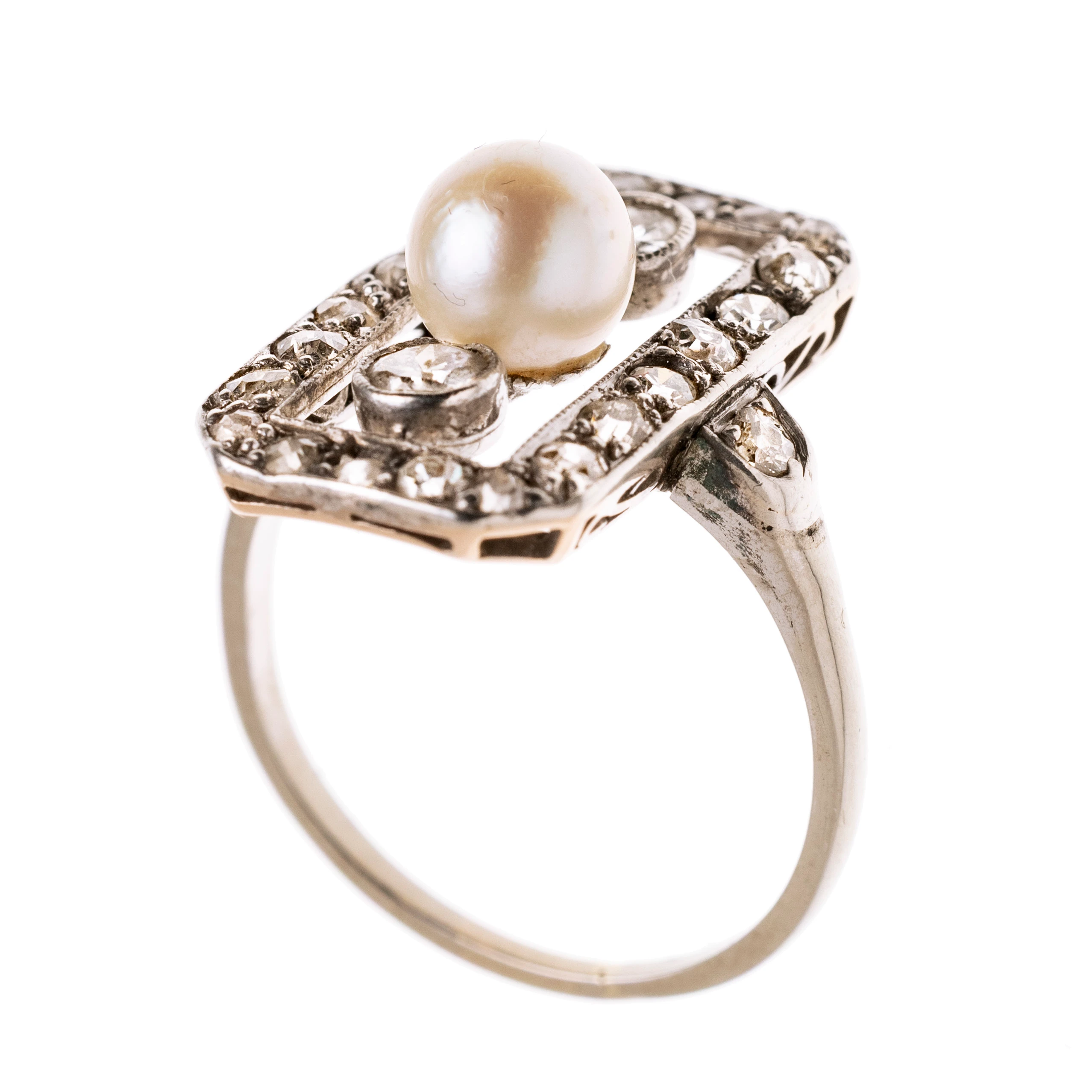 Ein Achteckig durchbrochener Ringkopf besetzt mit 22 Altschliffdiamantenje ca. 0.02 ct., Millégriffe verziert. Mittig in einer Reihe untereinander eine Perle, die von zwei Diamanten je ca. 0.10 ct in Zargenfassungen flankiert wird. Die Ringschultern sind ebenfalls mit je einem ca 0.03 ct Diamanten besetzt.