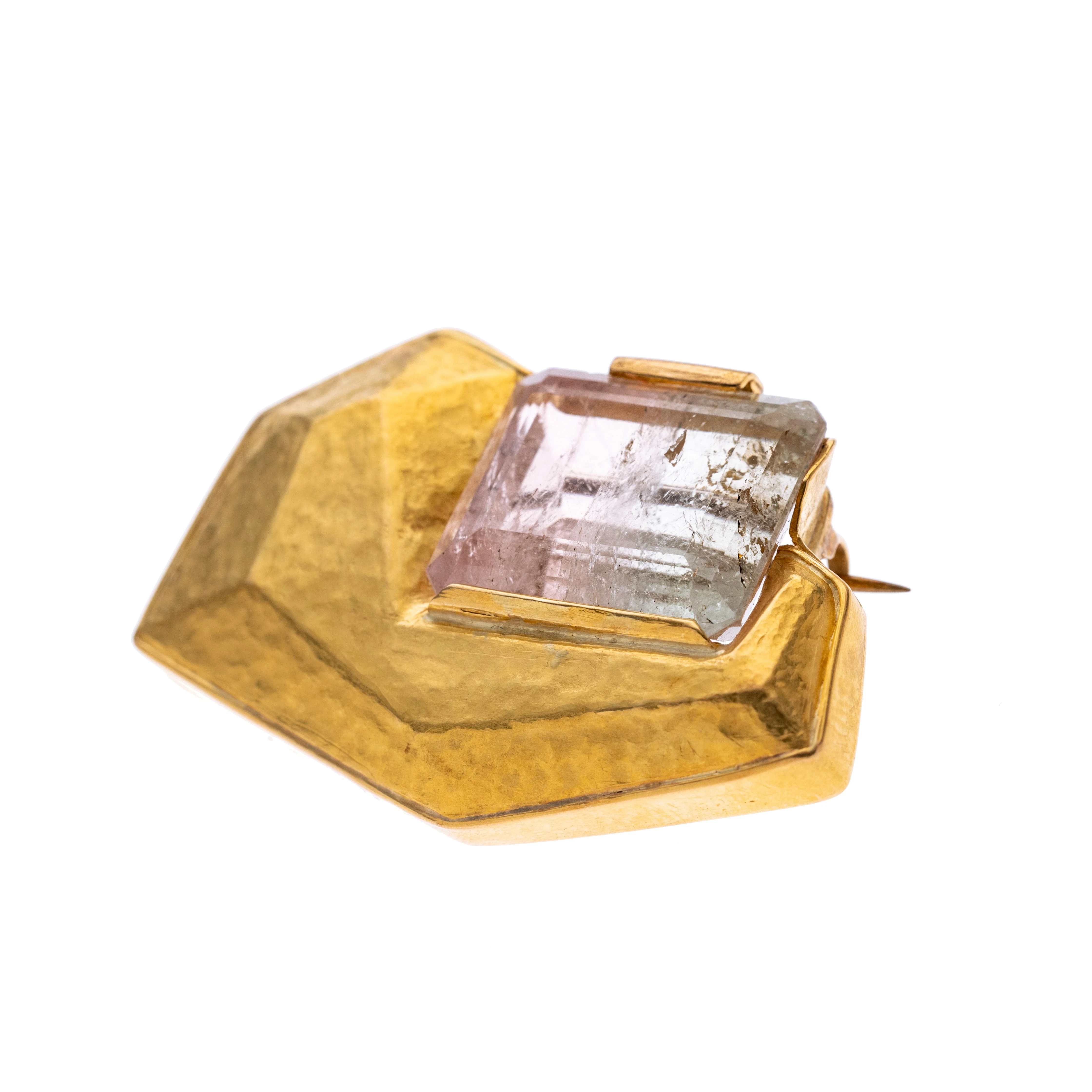 Turmalin ca. 27.30 ct. als ungeregelmäßges Rechtecks geschliffen, äußere Form konvex, gehämmert mit einem zweifarbigen Turmalin in Krappenfassung. Broschierung aus Metall.