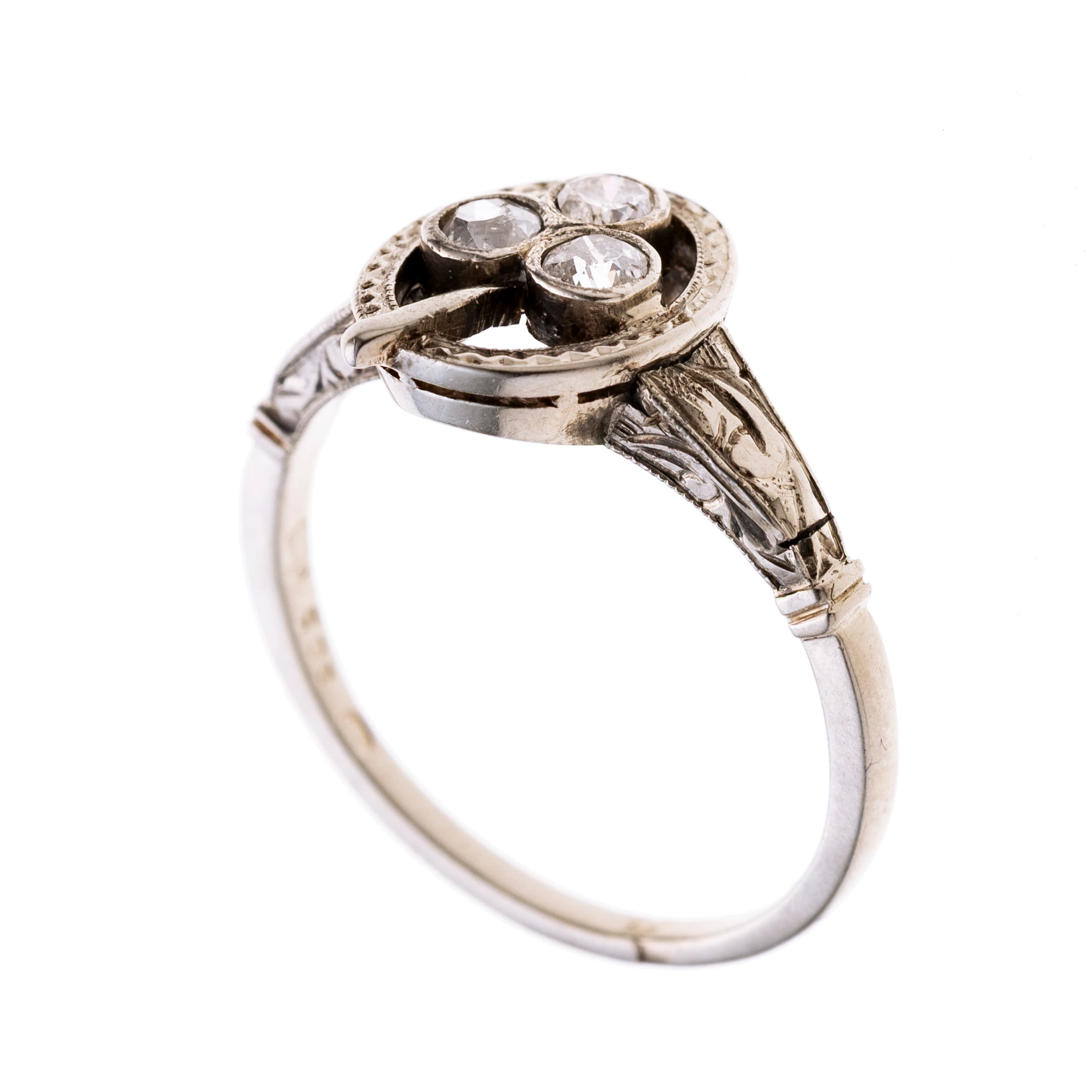an einer zarten, an den Ringschultern gravierten Schiene sitzt ein ovales Mittestück, geschmückt von einem dreiblättrigen Kleeblatt, besetzt mit Diamanten. Signiert "WT".
