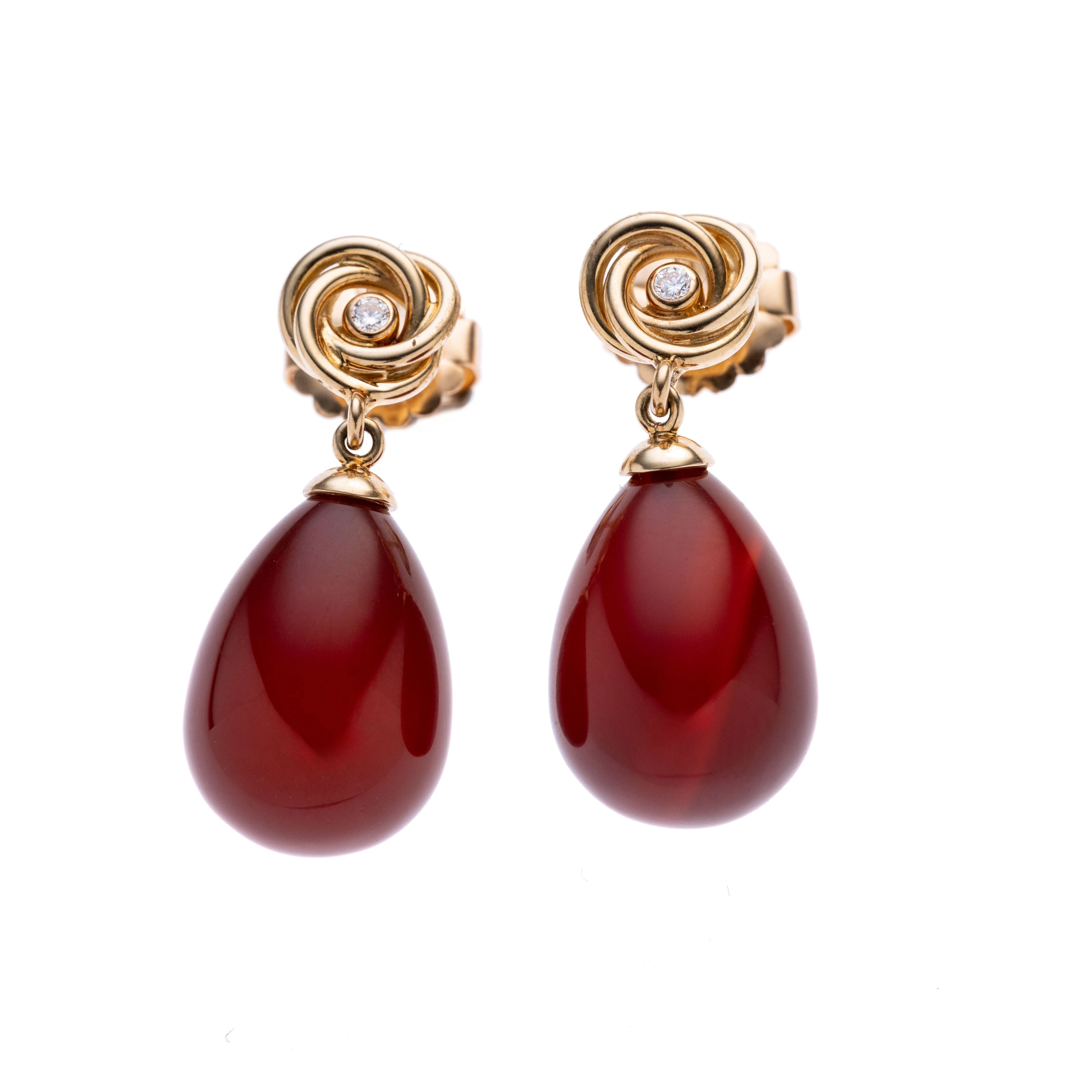 Je ein Kranz aus ineinander verschlungenen Ringen mit einem Brillanten, daran abgehängt eine rote Achat-Pampel.