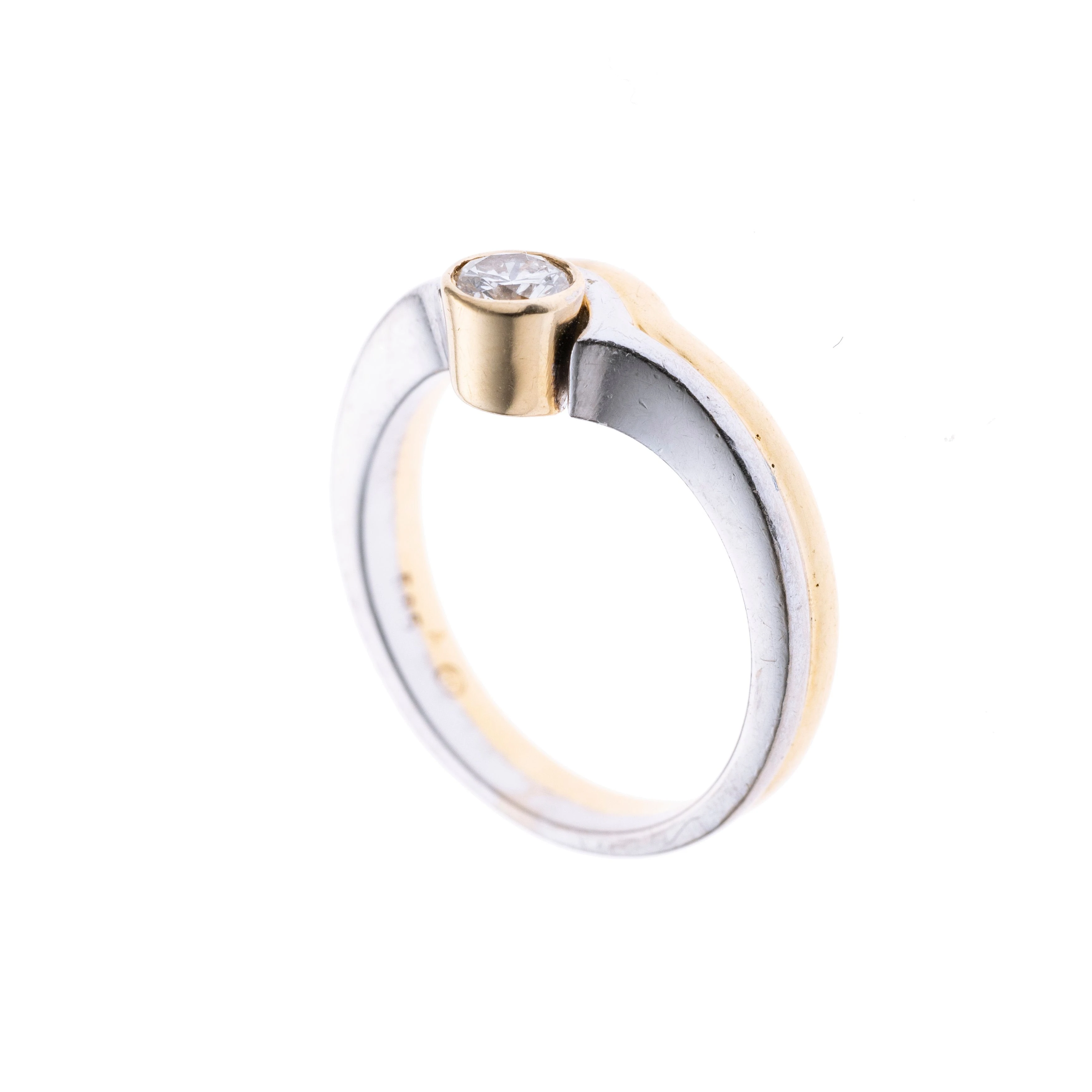 Ein Bicolorer Ring mit einem 0.25 ct Brillanten in Gelbgoldzarge über Bogenelementen.