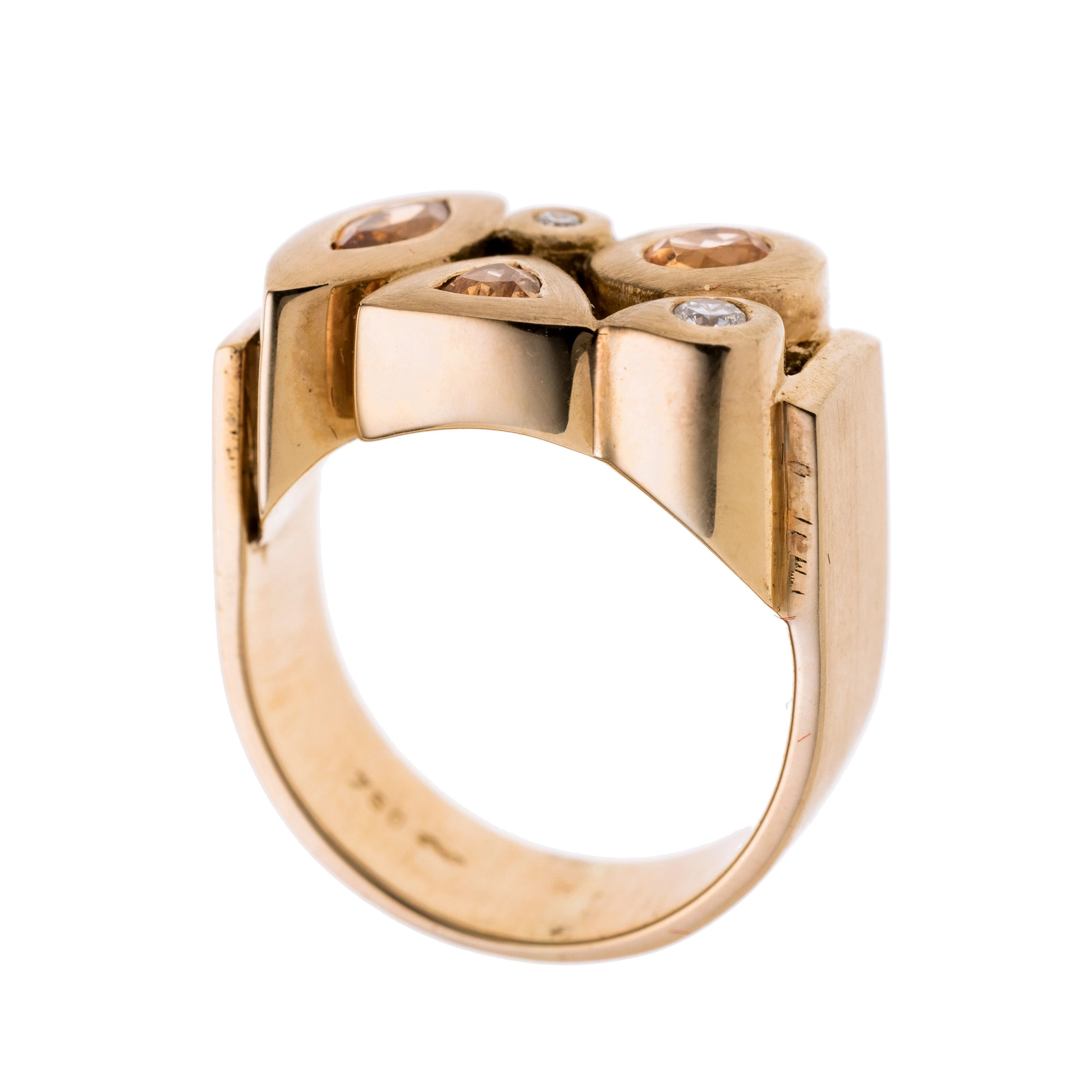 Eine U-förmige breite Ringschiene. Der Ringkopf besteht aus zwei Brillanten, einem ovalen, einem trillantförmigen und einem navetteförmigen Mandarin-Granat.