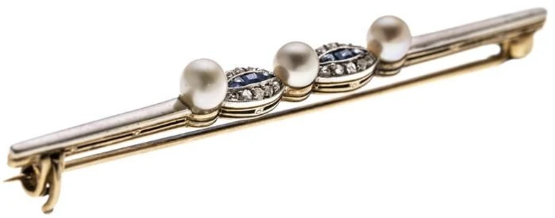 Besetzt mit drei Perlen, die zwei navetteförmigen Elemente flankieren, welche mit Diamanten und Saphiren besetzt sind.