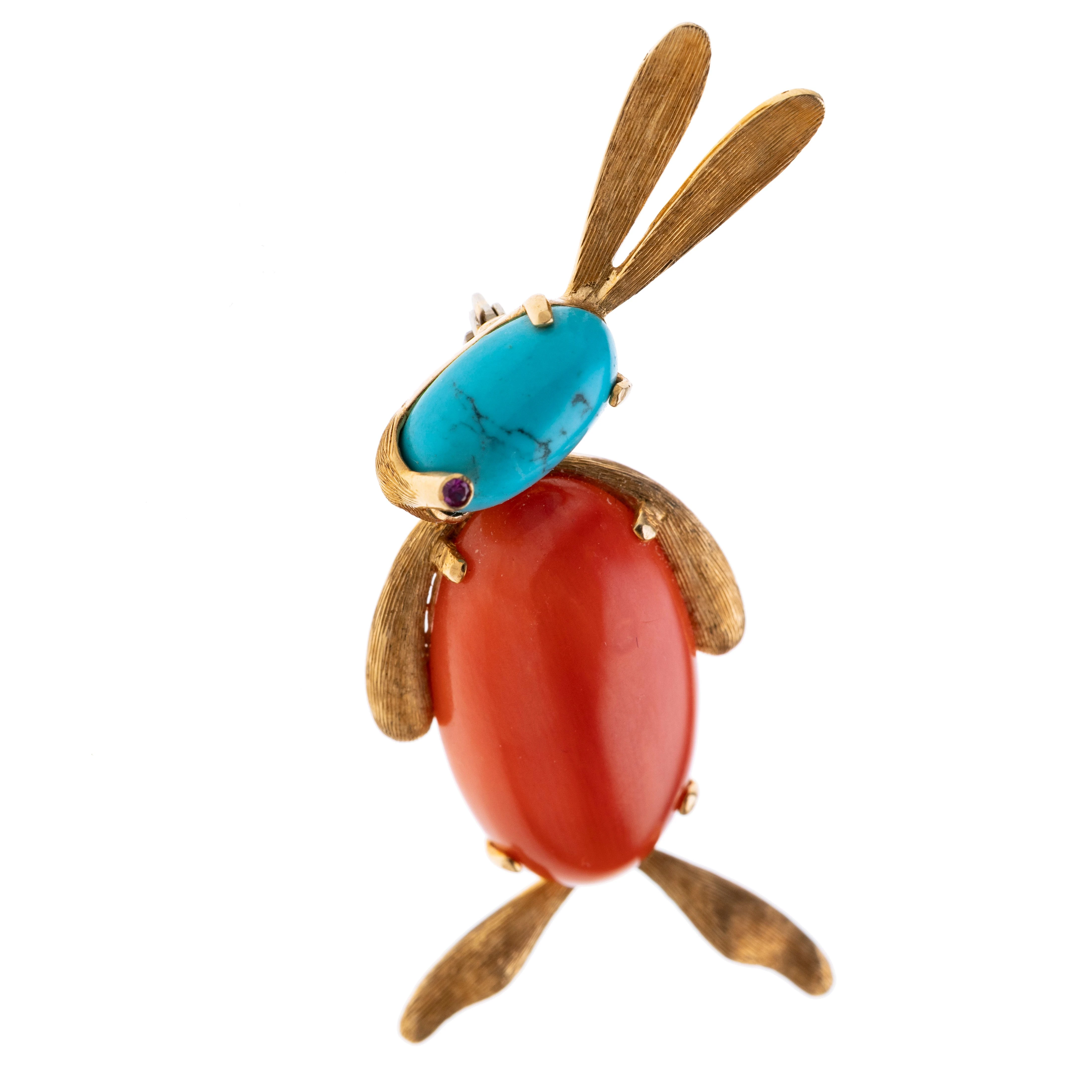 Ein Hase mit strukturierten Gelbgoldelementen. Der Kopf ist besetzt mit einem Türkis-Cabochon und einem kleinem Rubin als Nase. Der Körper besteht aus einem Korallen-Cabochon. Länge ca. 5,5 cm, Breite 2,2 cm. Broschierung aus Weißgold.
