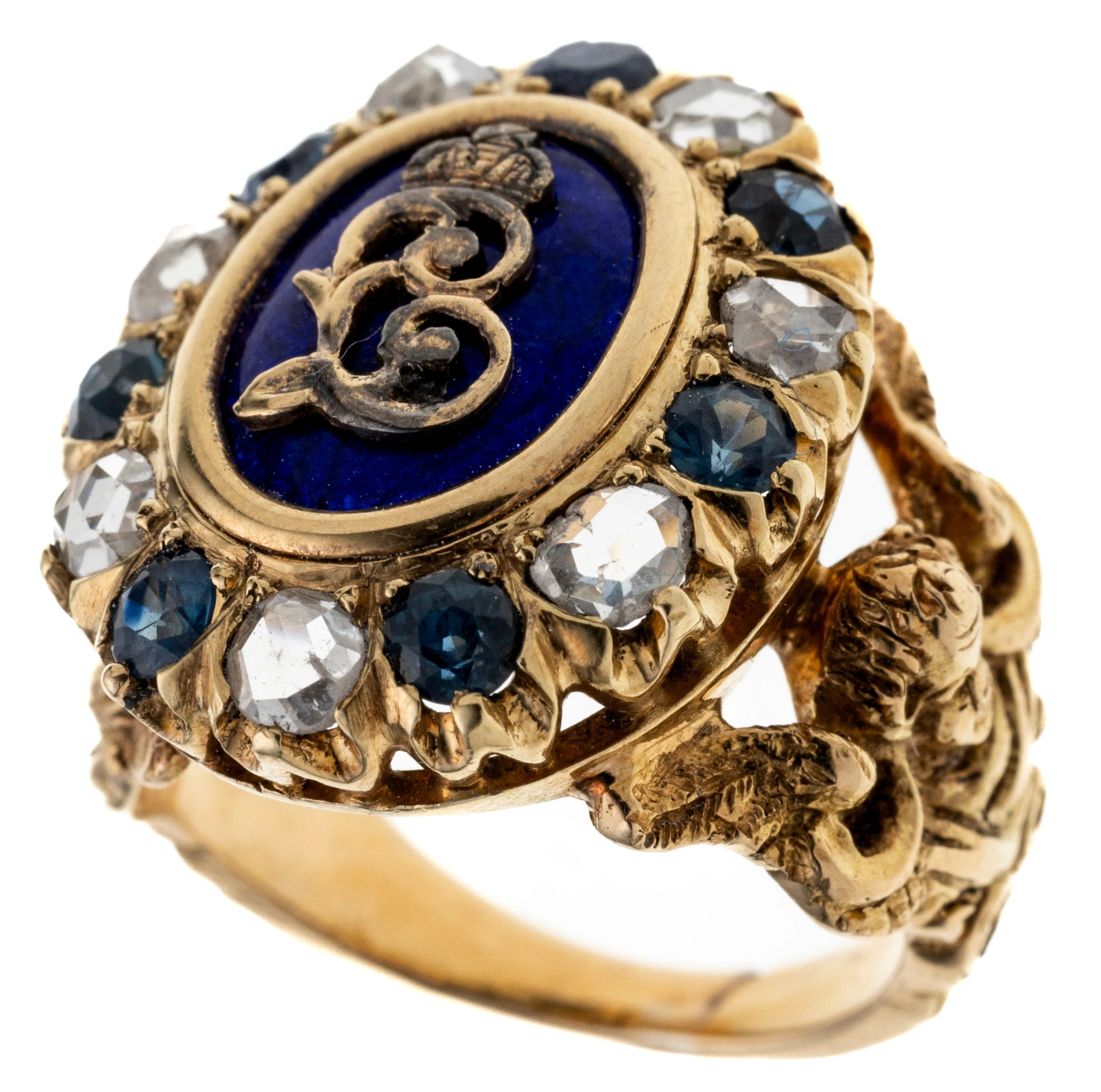 Ein sogenannter König Ludwig Ring mit gekröntem Monogramm L auf blauem Email, gerahmt von sieben Saphiren und sieben Diamanten. Massive Ringschiene mit seitlich zwei Engelsköpfen.