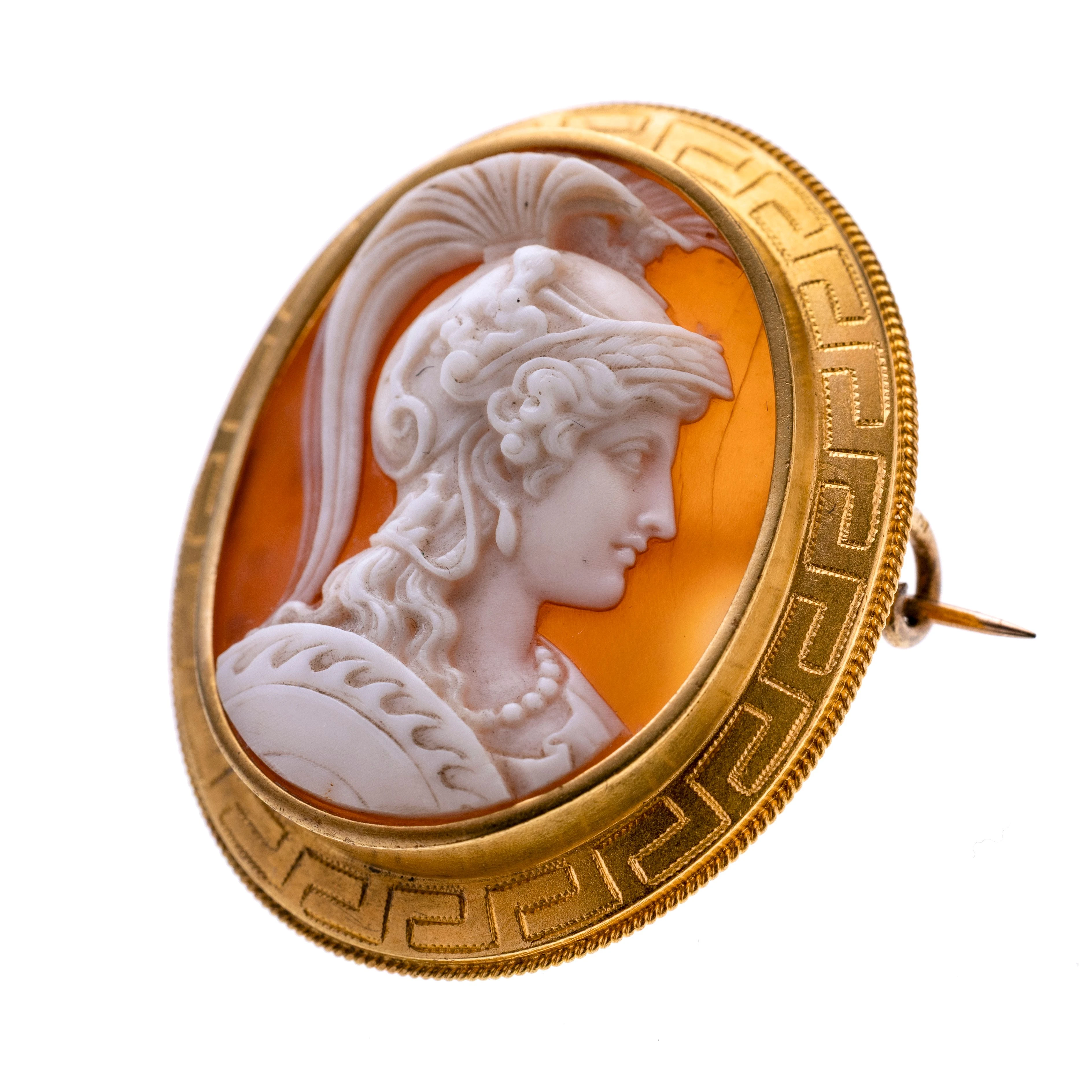 Eine Kamee mit der personifizierten Stadtgöttin Roms zuerkennen an den Darstellungen im Helm (Lupa capitolina und auf den Wangen der römische Adler. Die Fassung ist mit einem Mäanderband versehen. Typische Darstellung des Neoklassizismus.