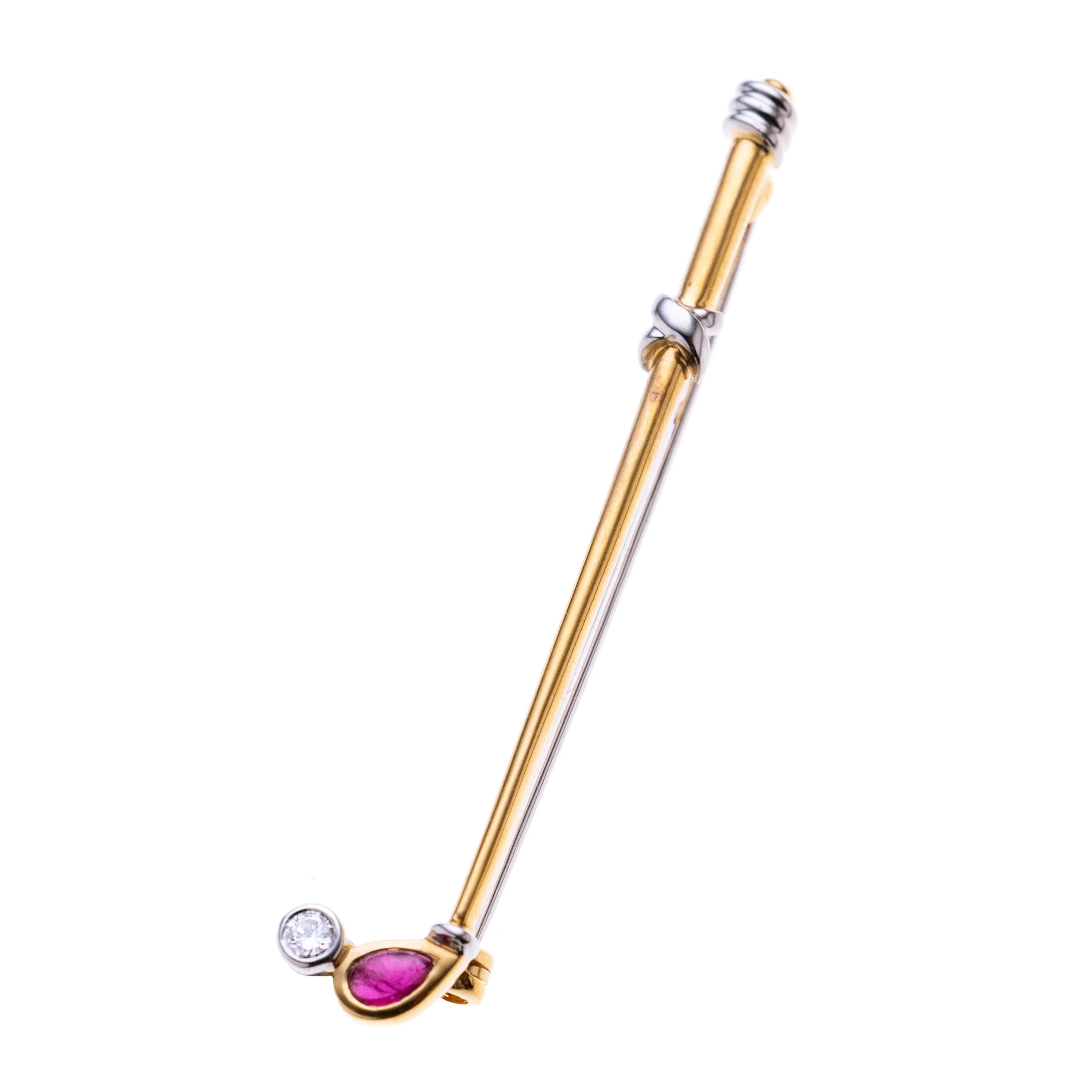 Ein Golfschläger mit einem tropfenförmigen Rubin-Cabochon und einen in Weißgold gefassten Brillanten als Golfball.
