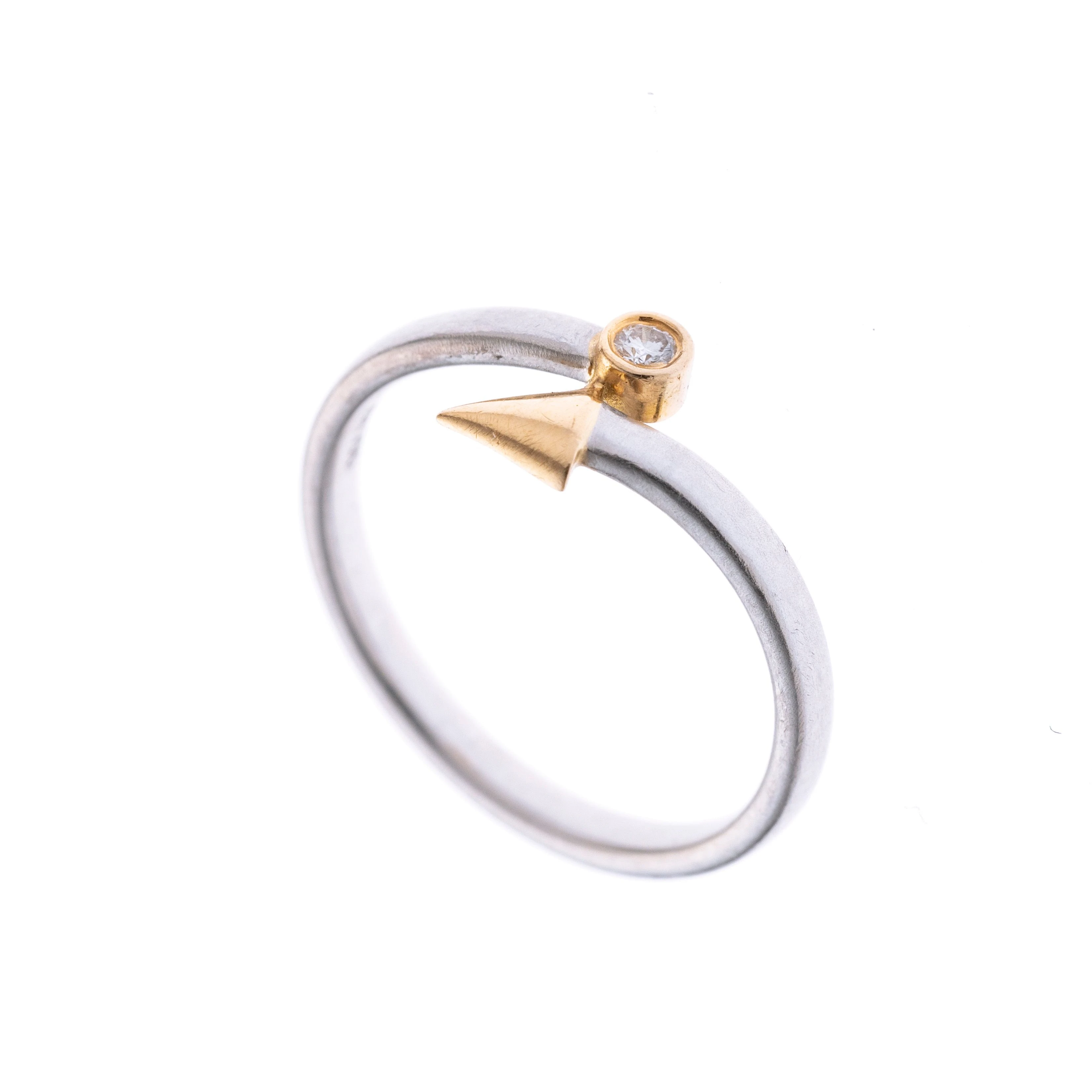 Ein Ring in Form eines Pfeiles mit gelbgoldener Spitze und einem ca. 0.03 ct großem Brillanten in gelbgoldener Zargenfassung.