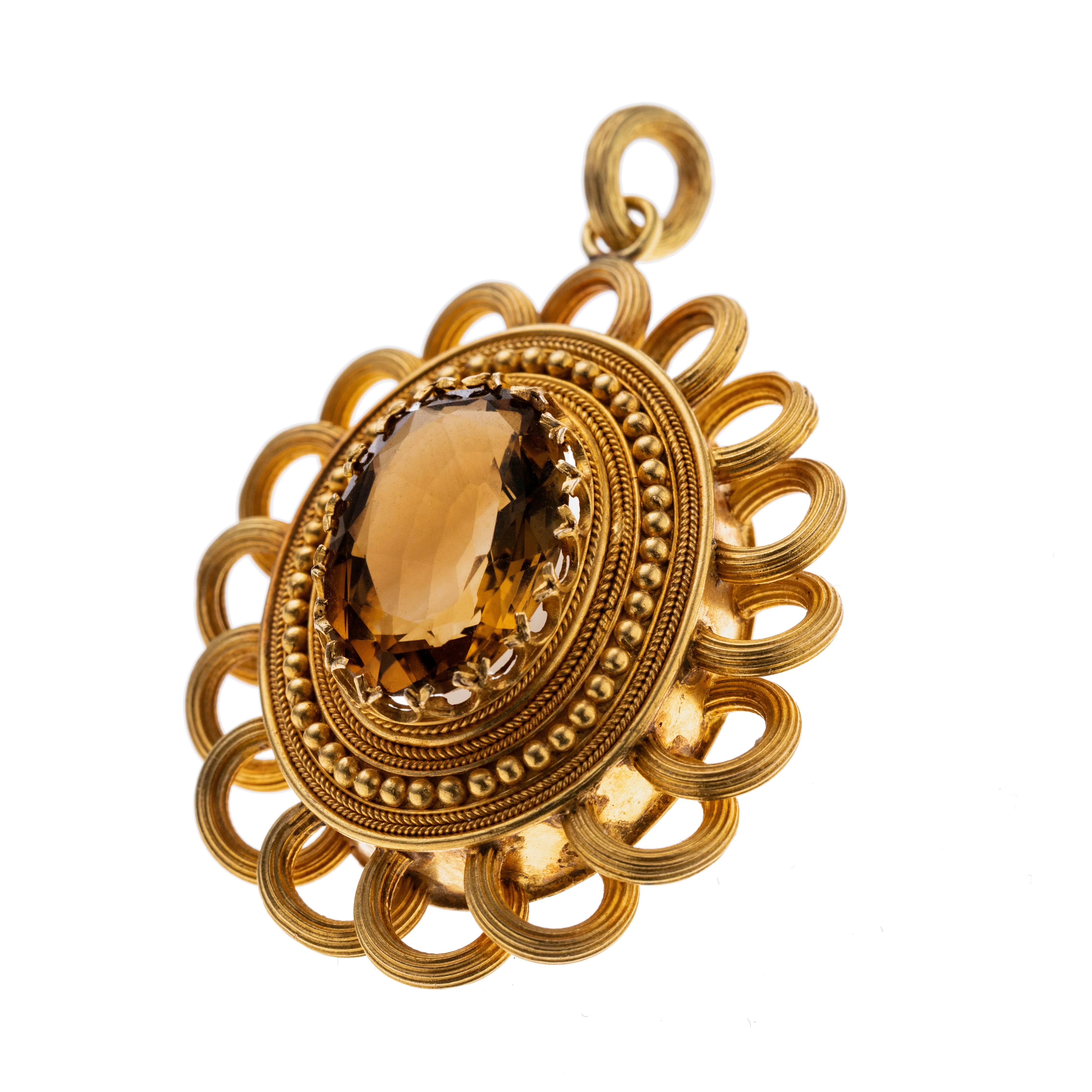 Ein Medaillon-Anhänger darin mittig ein ovaler, facettierter Citrin in einer Krönchenfassung, ornamentierter Rahmen umrundet von 16 gerillten Goldbögen; rückseitig eine ovale Öffnung für ein Erinnerungsstück oder Foto hinter facettiertem Glas. deckel aus 333er GG,