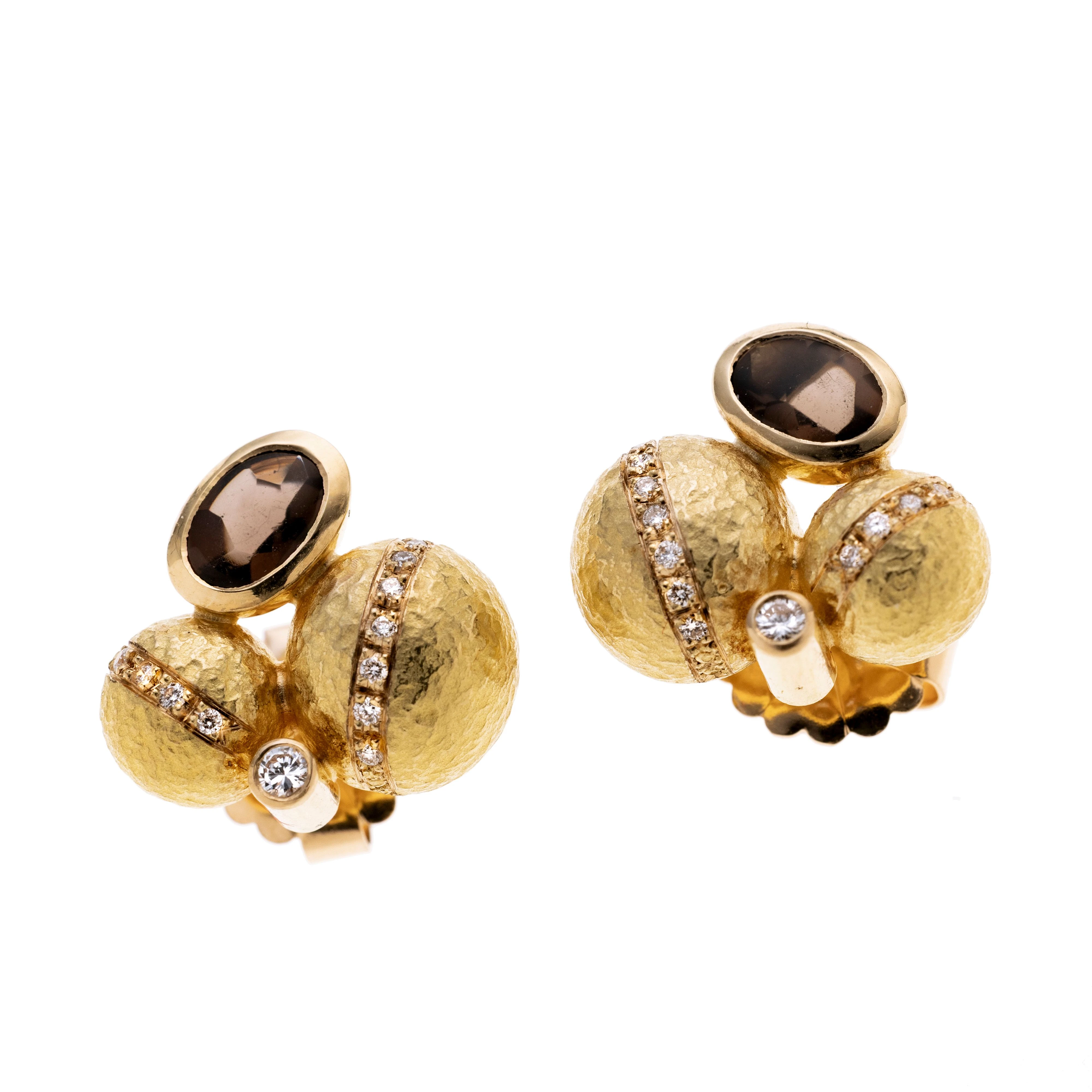 Je ein ovaler Rauchquarz bufftop Cabochon in Zargenfassung an zwei gelbgoldenen Halbkugeln mit je mittig einem Streifen Diamanten, dazwischen je ein Brillant in Zargenfassung. Rückstecker auch Roségold.