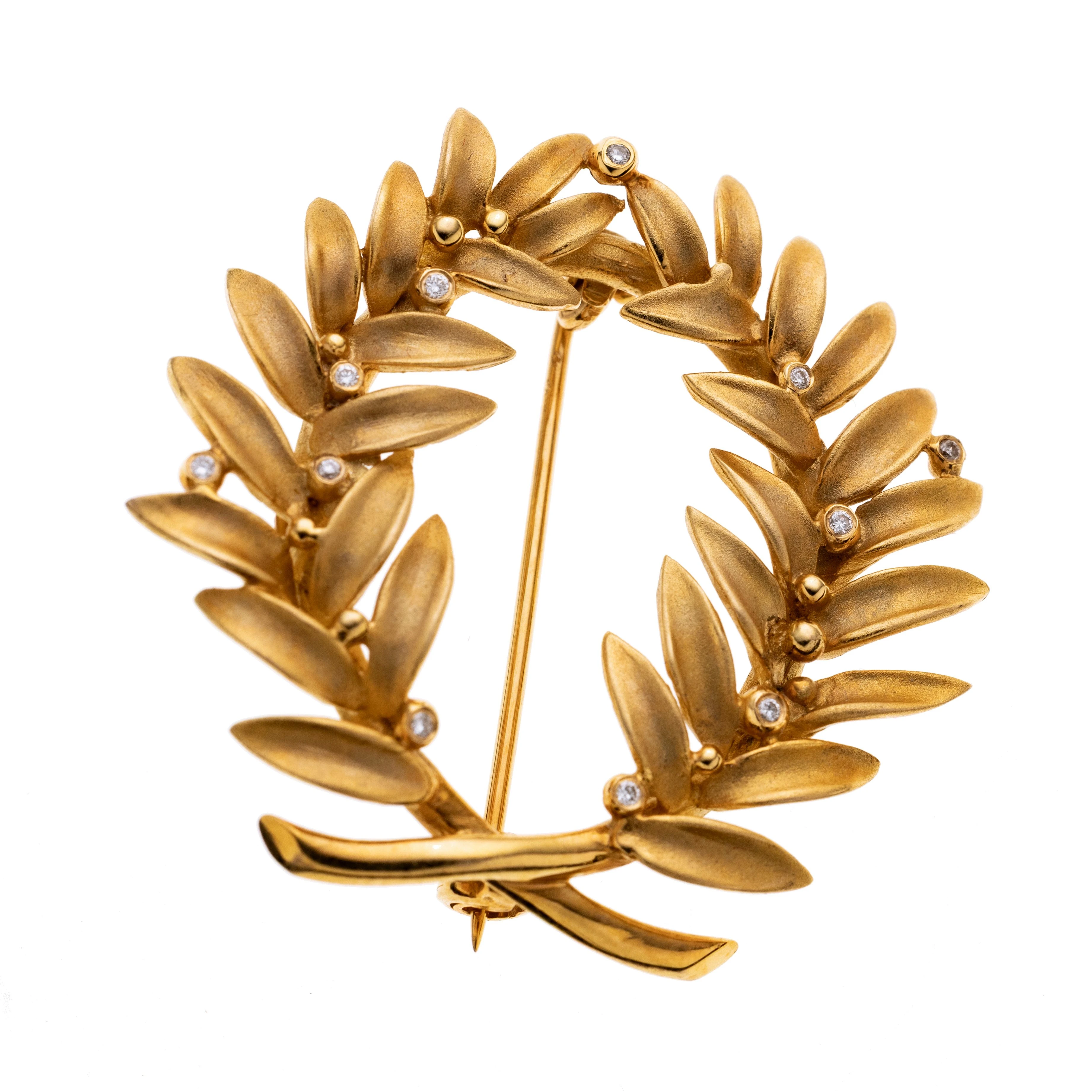 Eine Brosche im Stil eines Lorbeerkranz gefertigt aus mattiertem, tw poliertem 750/- Gelbgold mit 11 Brillanten von insg. ca. 0,02 ct.