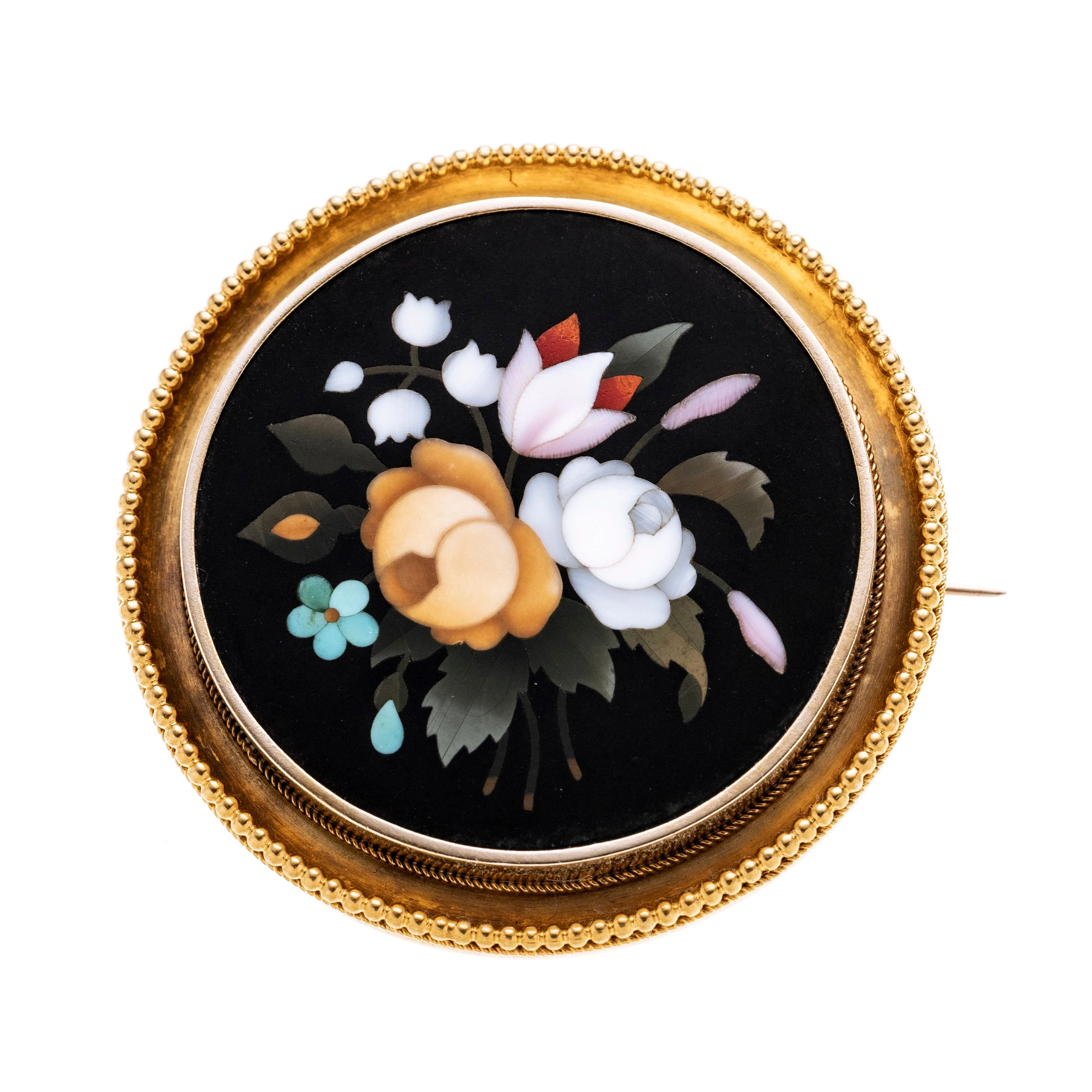Ein Pietra dura Mosaik aus Quarzen in Blumenoptik mit einem Gelbgold rand. Broschierung aus 585 Gold.