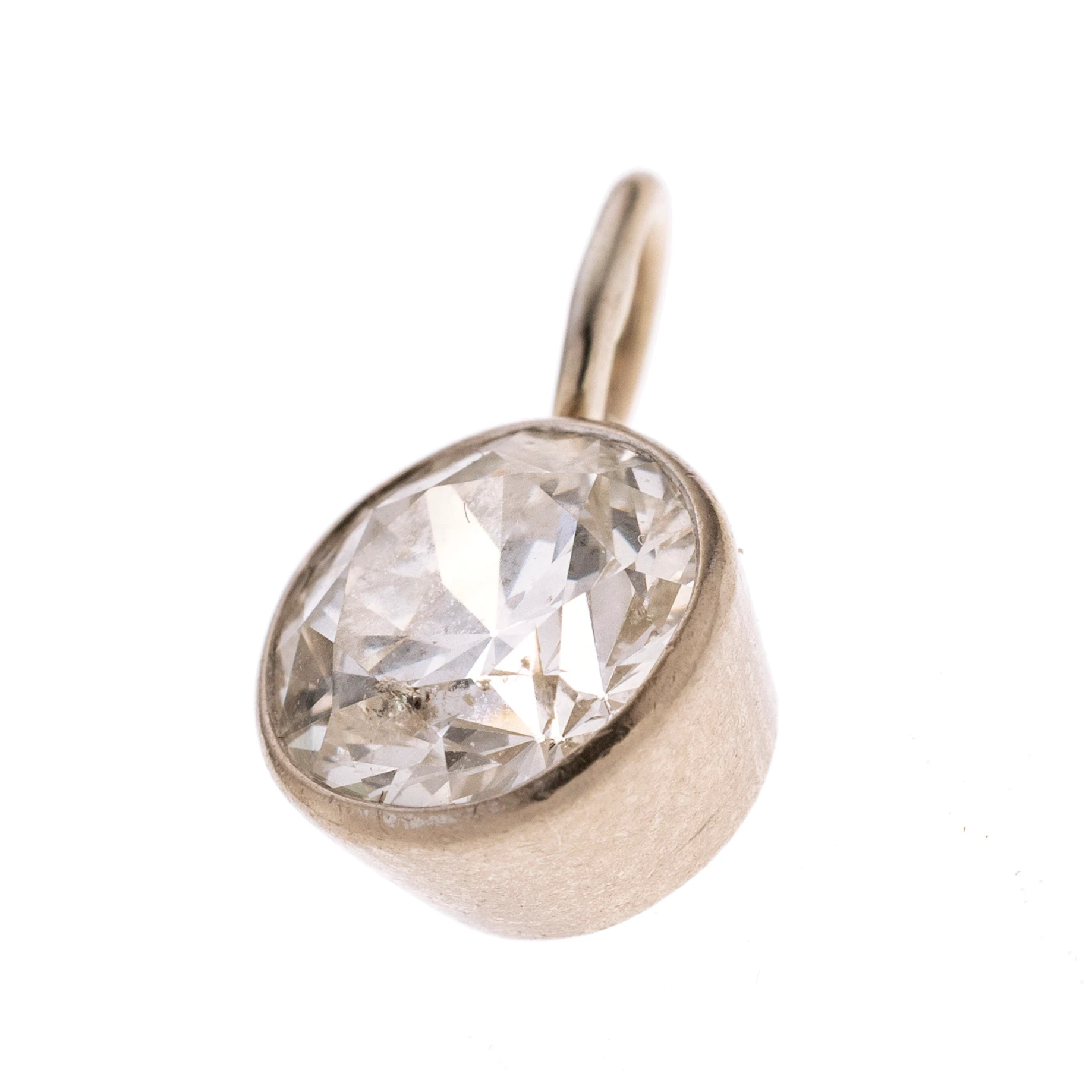 Ein Diamant in konischer Zargenfassung mit einer Anhängeröse. Länge mit Öse 1,3 cm, Breite 21,8 cm.