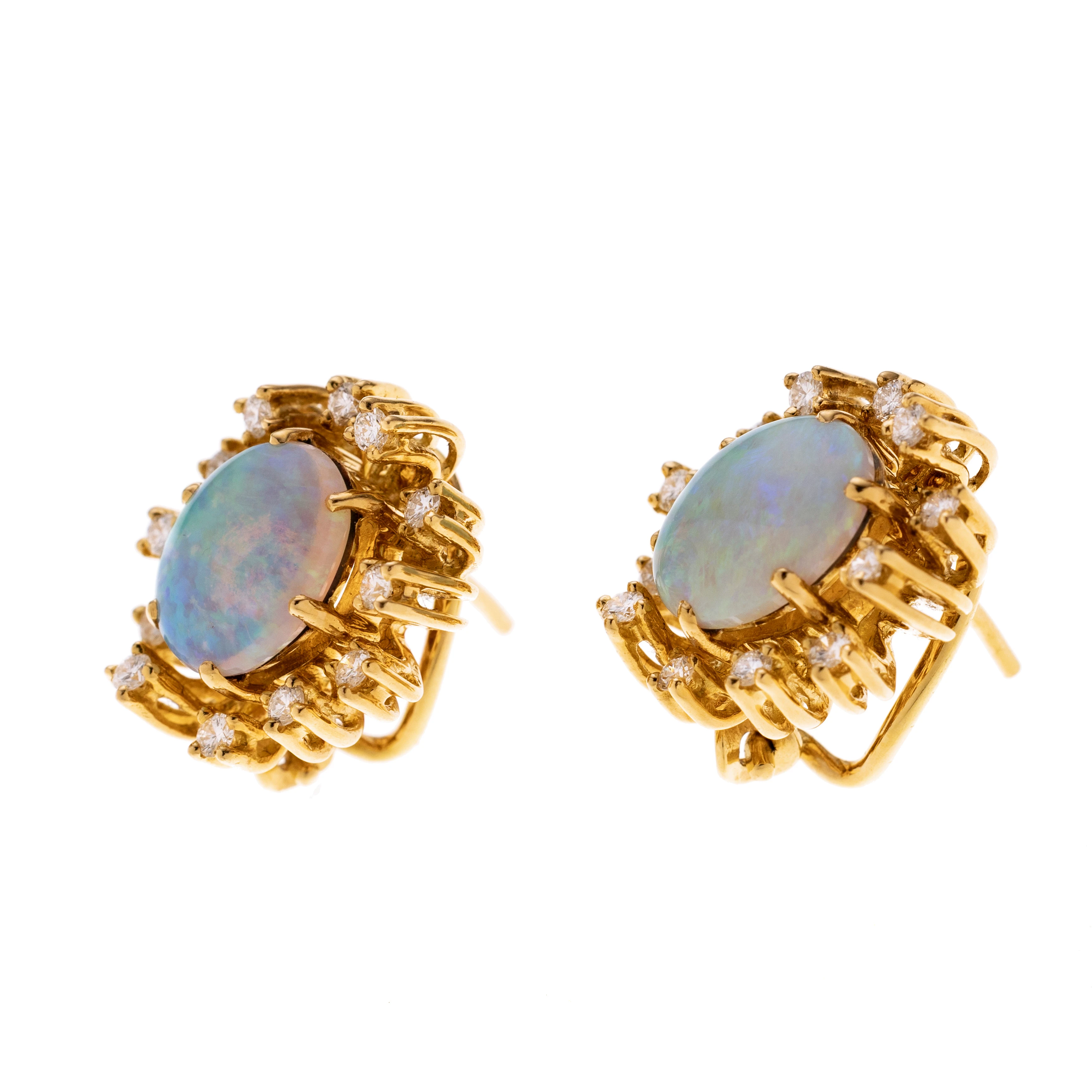 Je ein Opal-Cabochon der locker von 12 unterschiedlich hoch gefassten Diamanten karmoisiert wird.