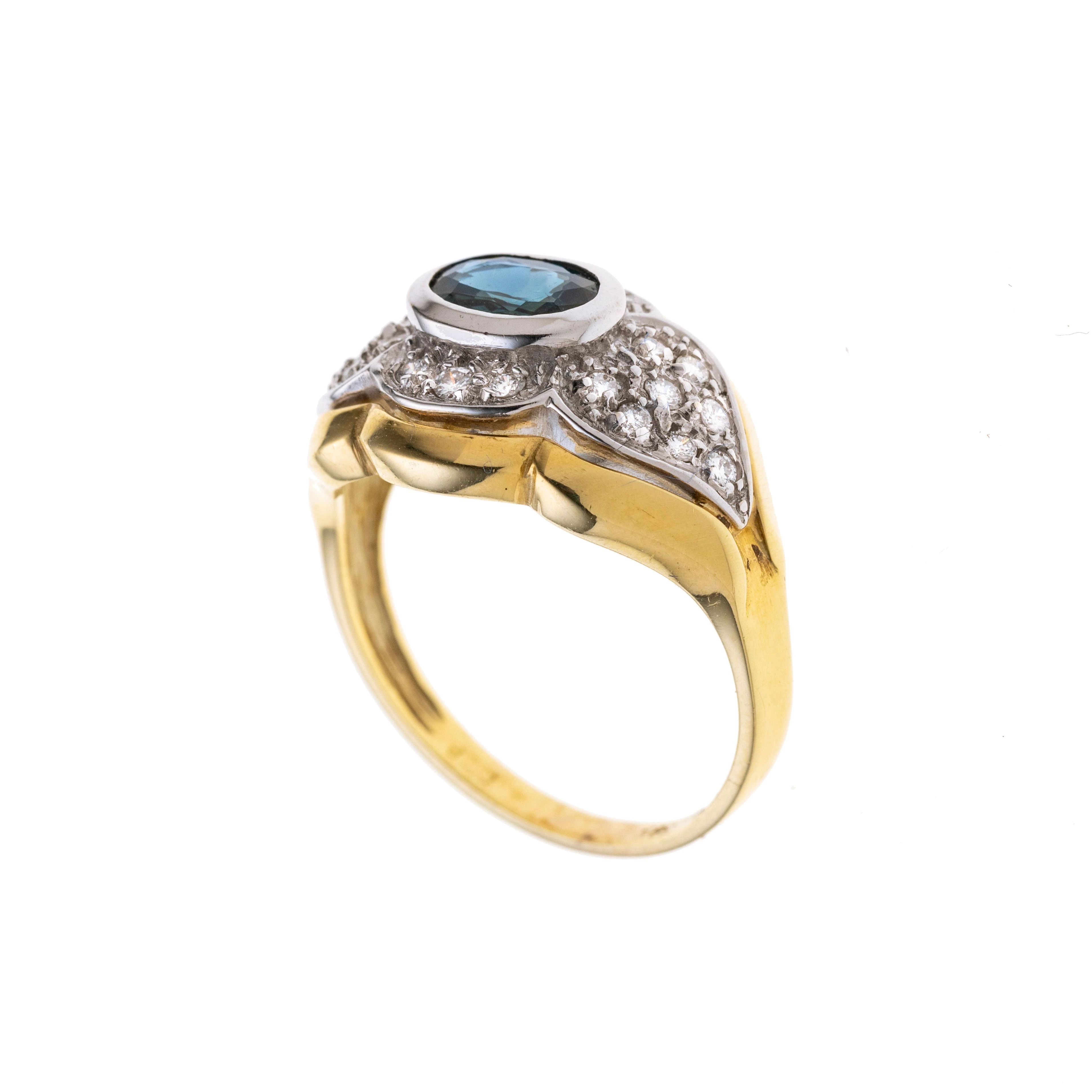 Ein ovaler Saphir in Weißgold gefasst und von einem blütenartigen Ringkopf gerahmt, der mit insgesamt 22 Diamanten besetzt ist.