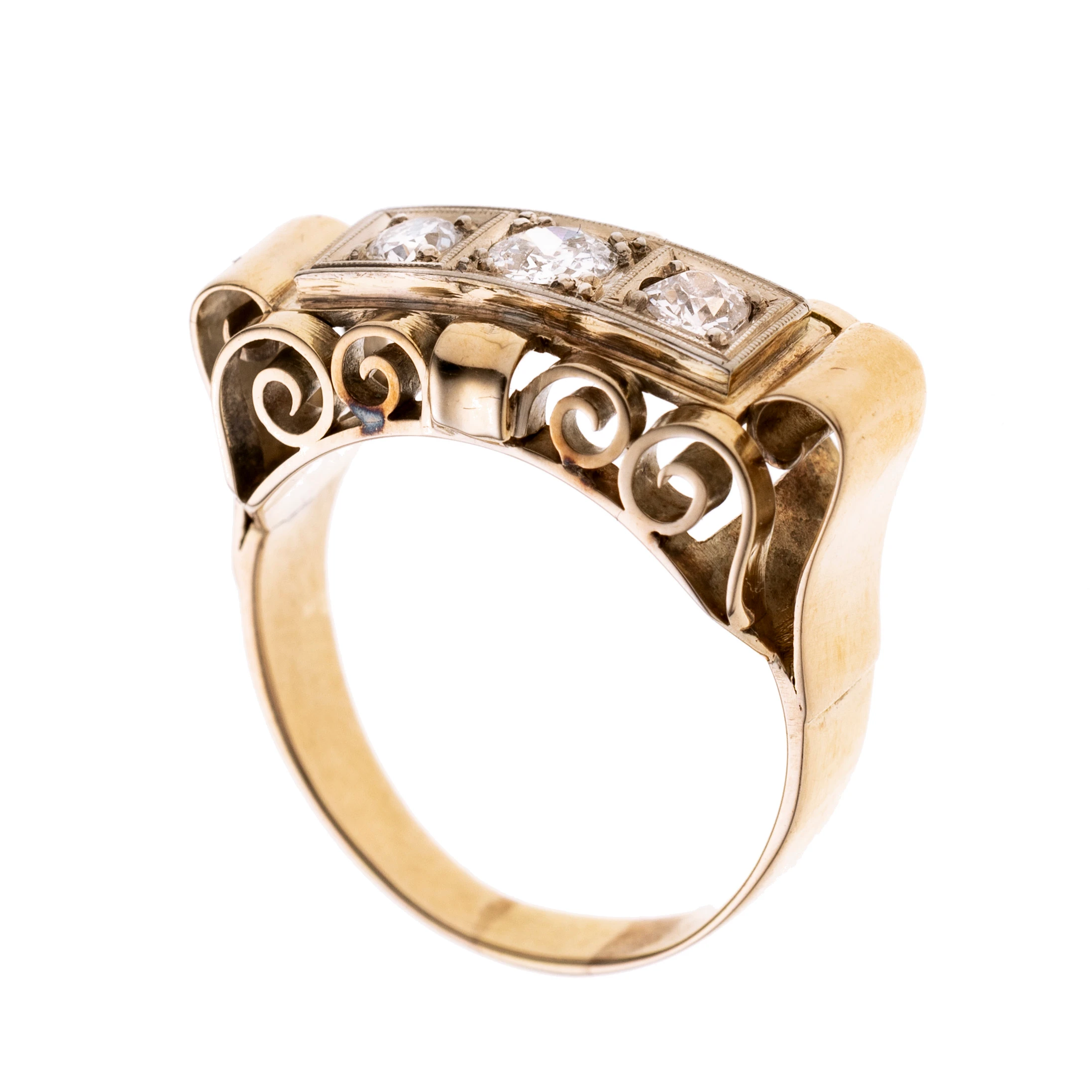 Rechteckiger Ringkopf, seitlich ajour gearbeitet mit Volutenlementen. Mittig drei Altschliffdiamanten (0.12/0.20/0.12 ct) in einer Reihe quadratisch gefasst, in Weißgold mit Millégriffe verziert. Signiert.