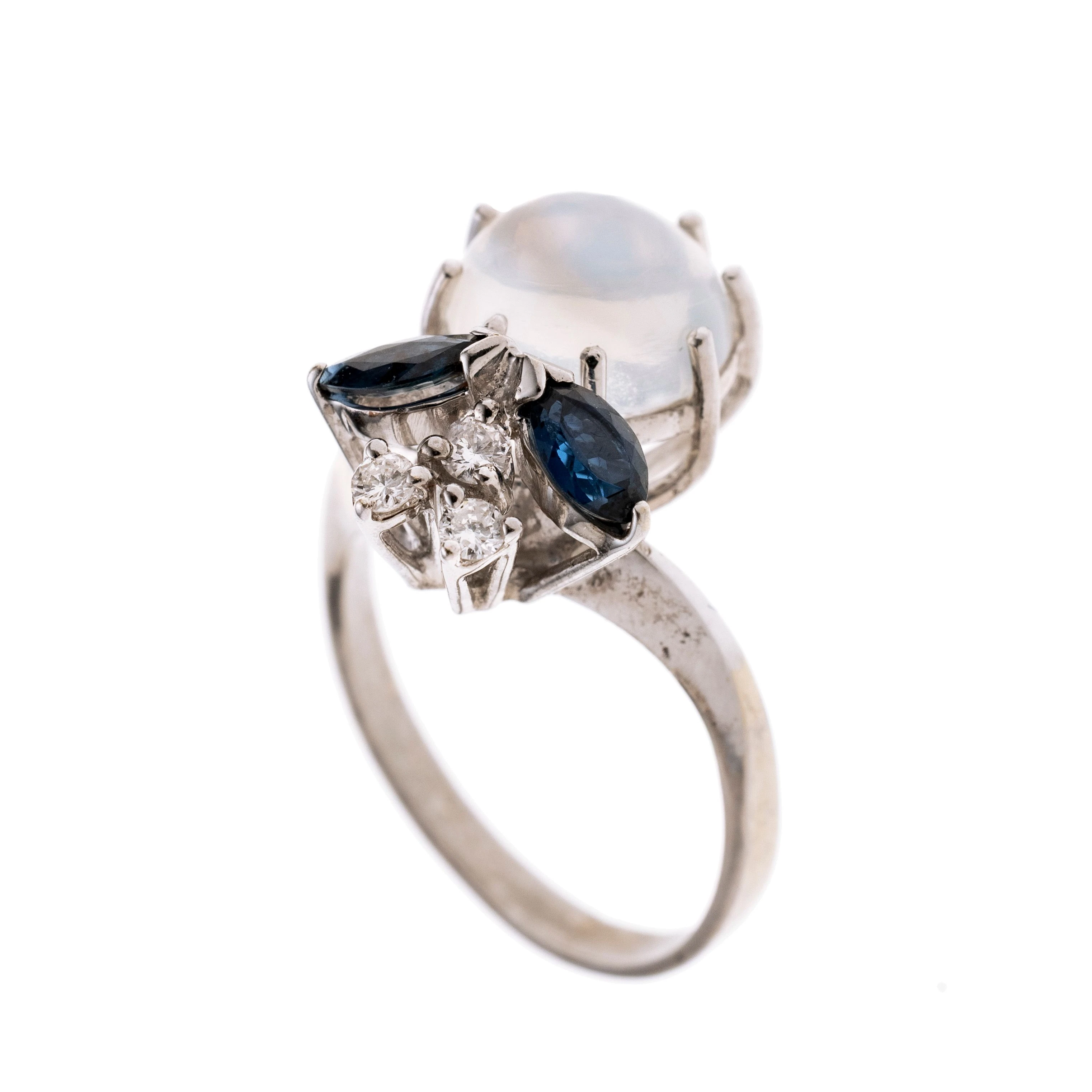 Ein Ringkopf in Form eines Insektes, besetzt mit einem runden Mondstein-Cabochon, zwei Saphir-Navetten und drei Brillanten.