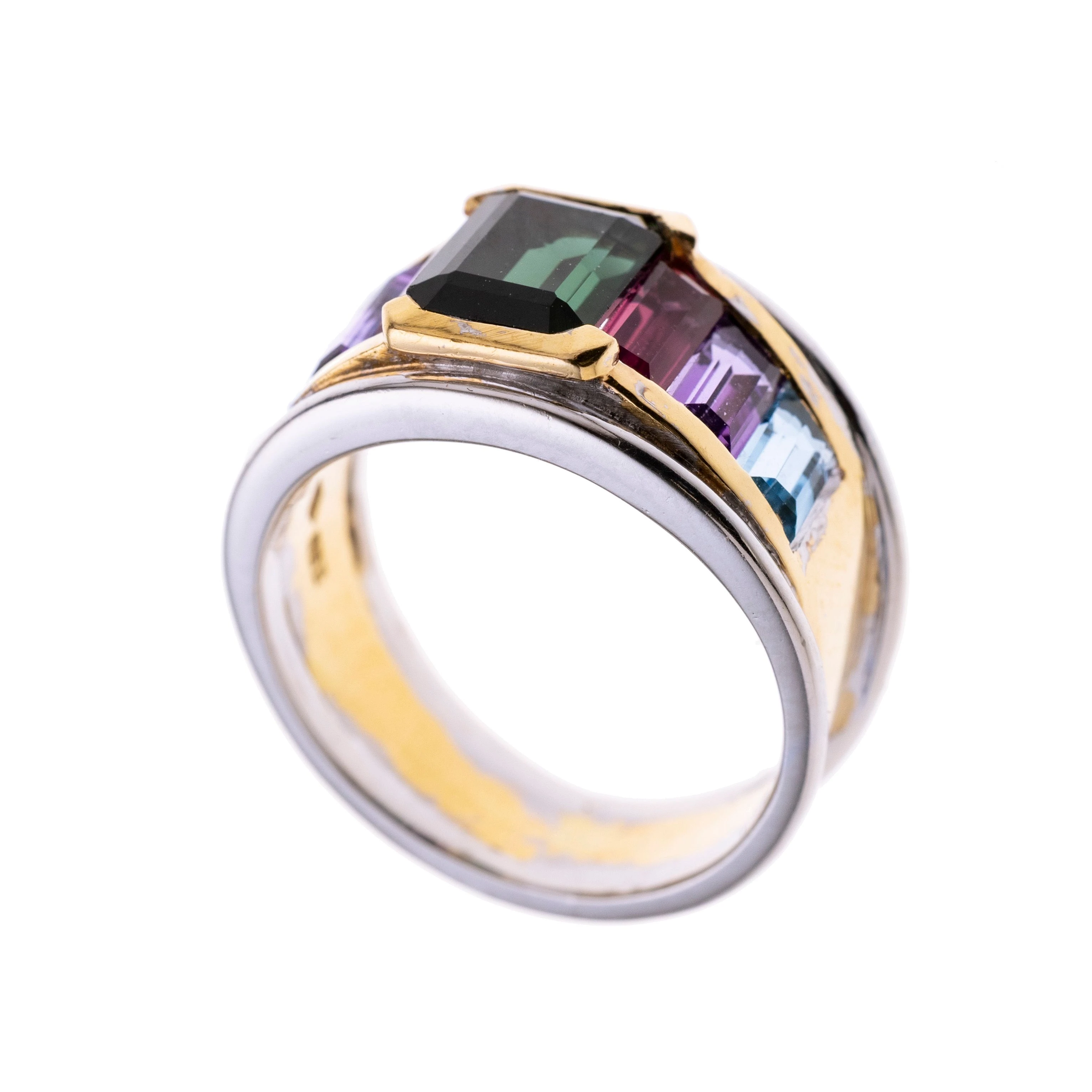 Ein Bandring mit mittig einem Turmalin in Zargenfassung, flankiert wird dieser von je einem rosa Turmalin, Amethyst und Aquamarin in Kanalfassung.  der Rand der Ringschiene wurde aus Weißgold gearbeitet.