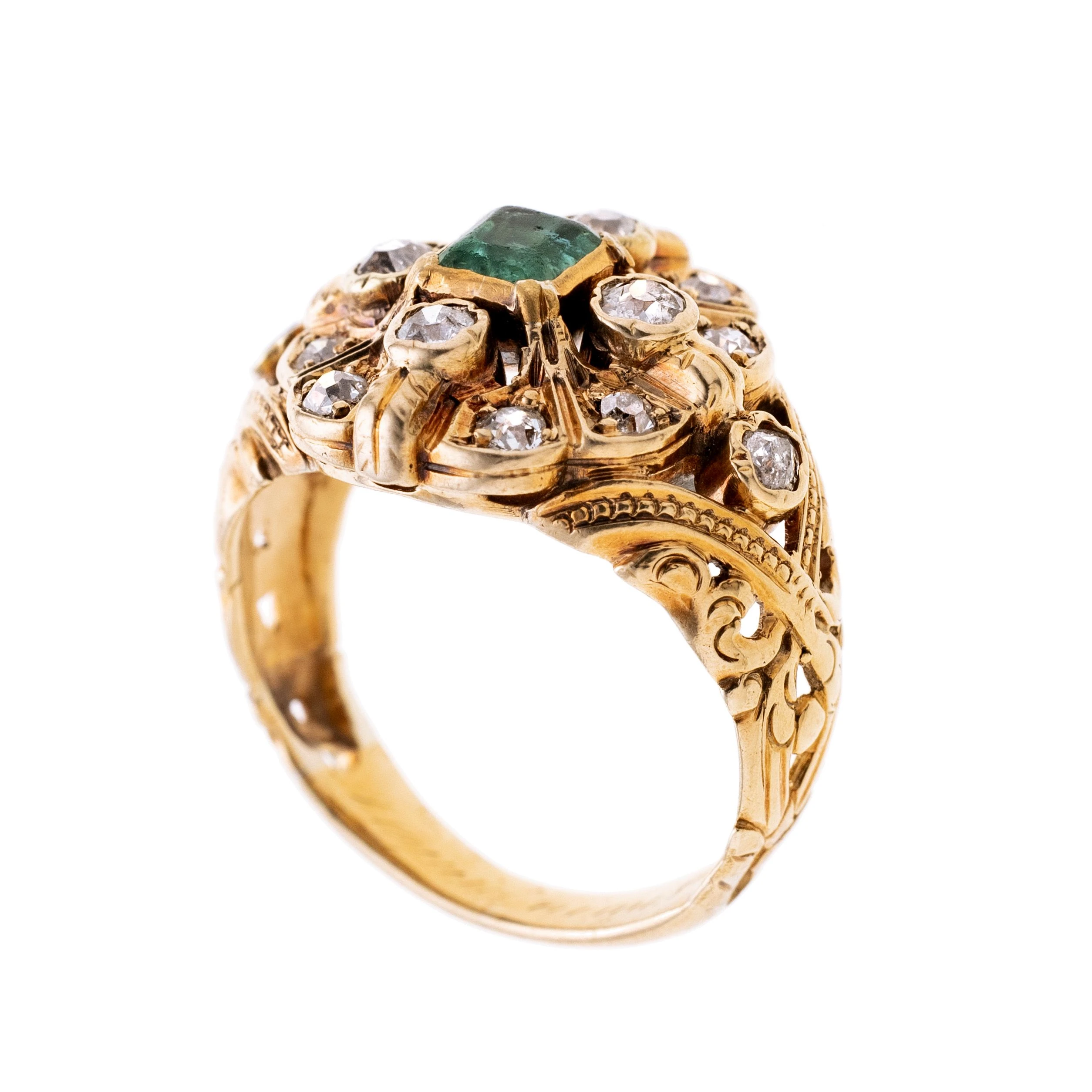 Ein runder Ringkopf mit einem Smaragd von ca. 0,50 ct und 14 Altschliff-Diamanten von ca. 0,62 ct. Eine verspielte Ringschiene,.