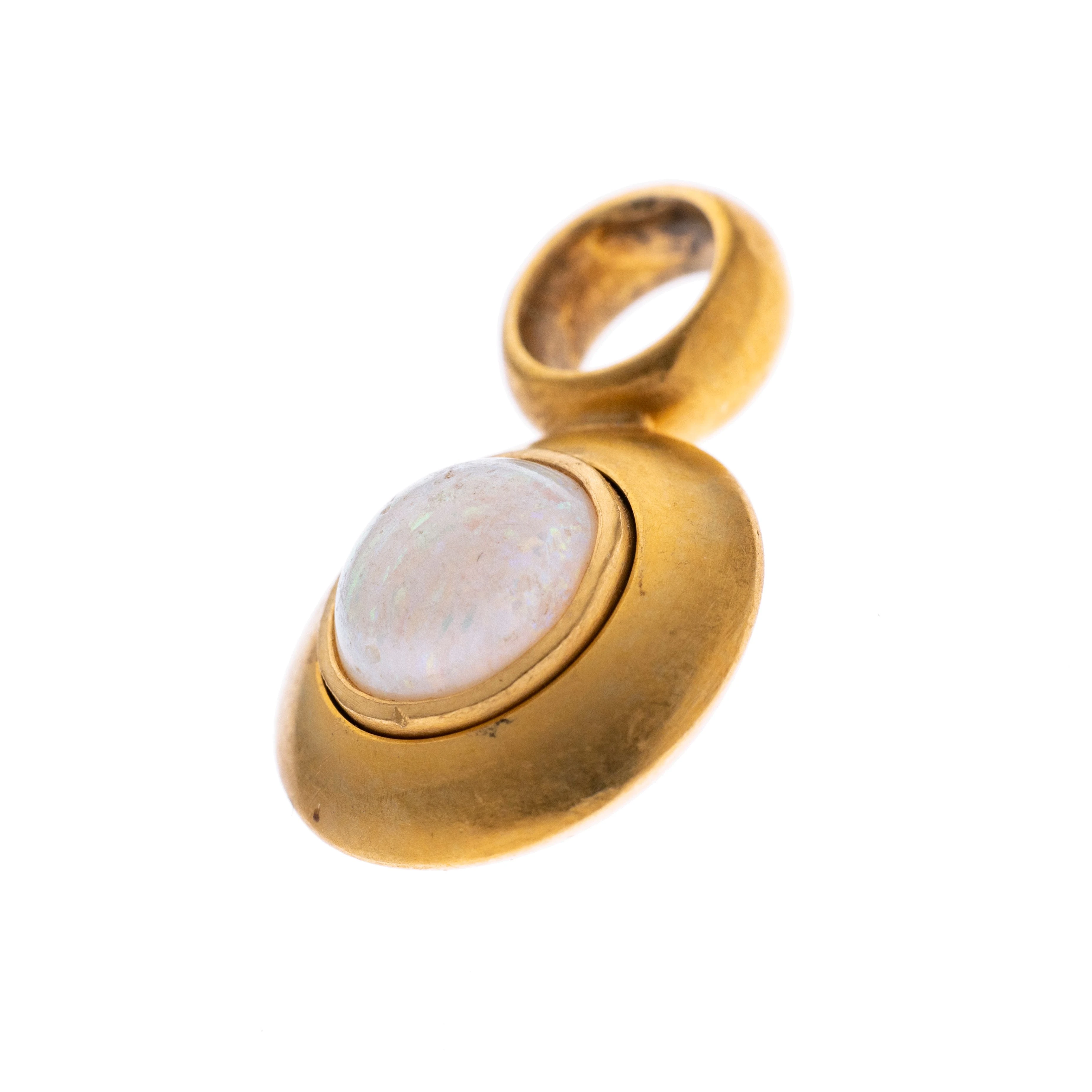 Ein runder opal-Cabochon in breiter Zargenfassung unter einer großen Öse.