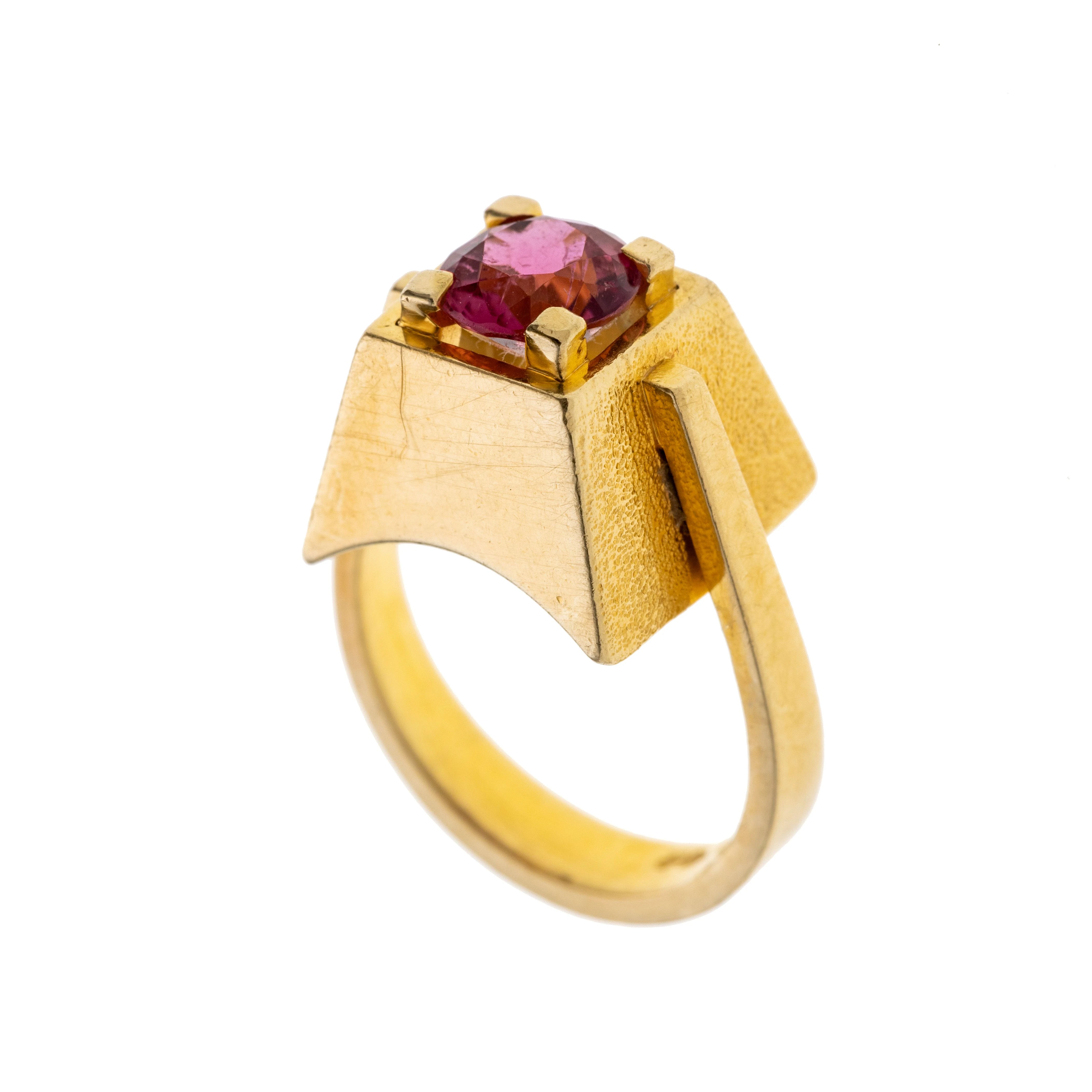 Ein pyramidenstufenförmiger Ringkopf mit einem pinken Turmalin in Krappen gefasst. Signiert „Conti“. "